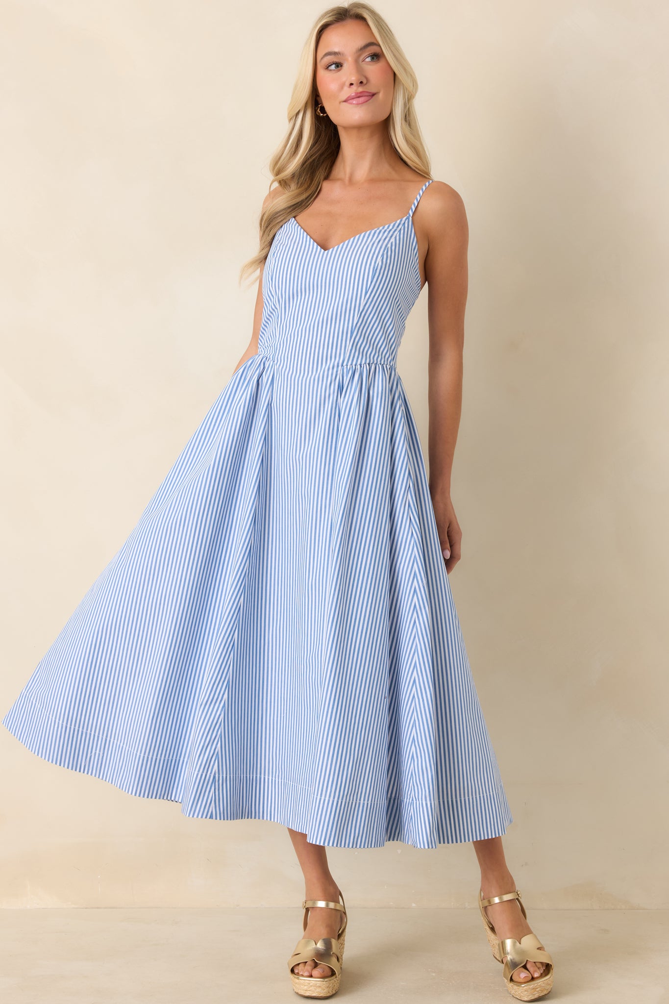Vertical striped midi dress featuring delicate straps and balanced shape.