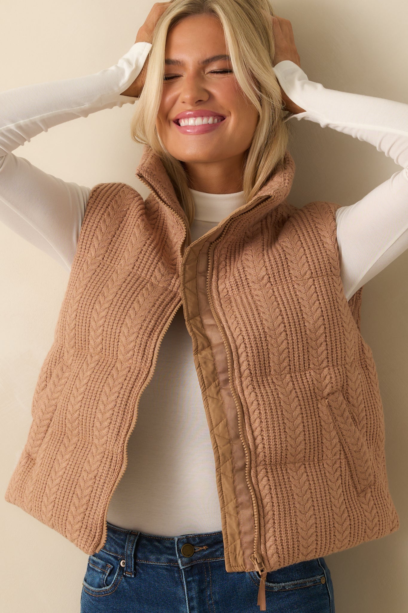 Detailed view of the vest’s functional pocket and quilted cable knit exterior.
