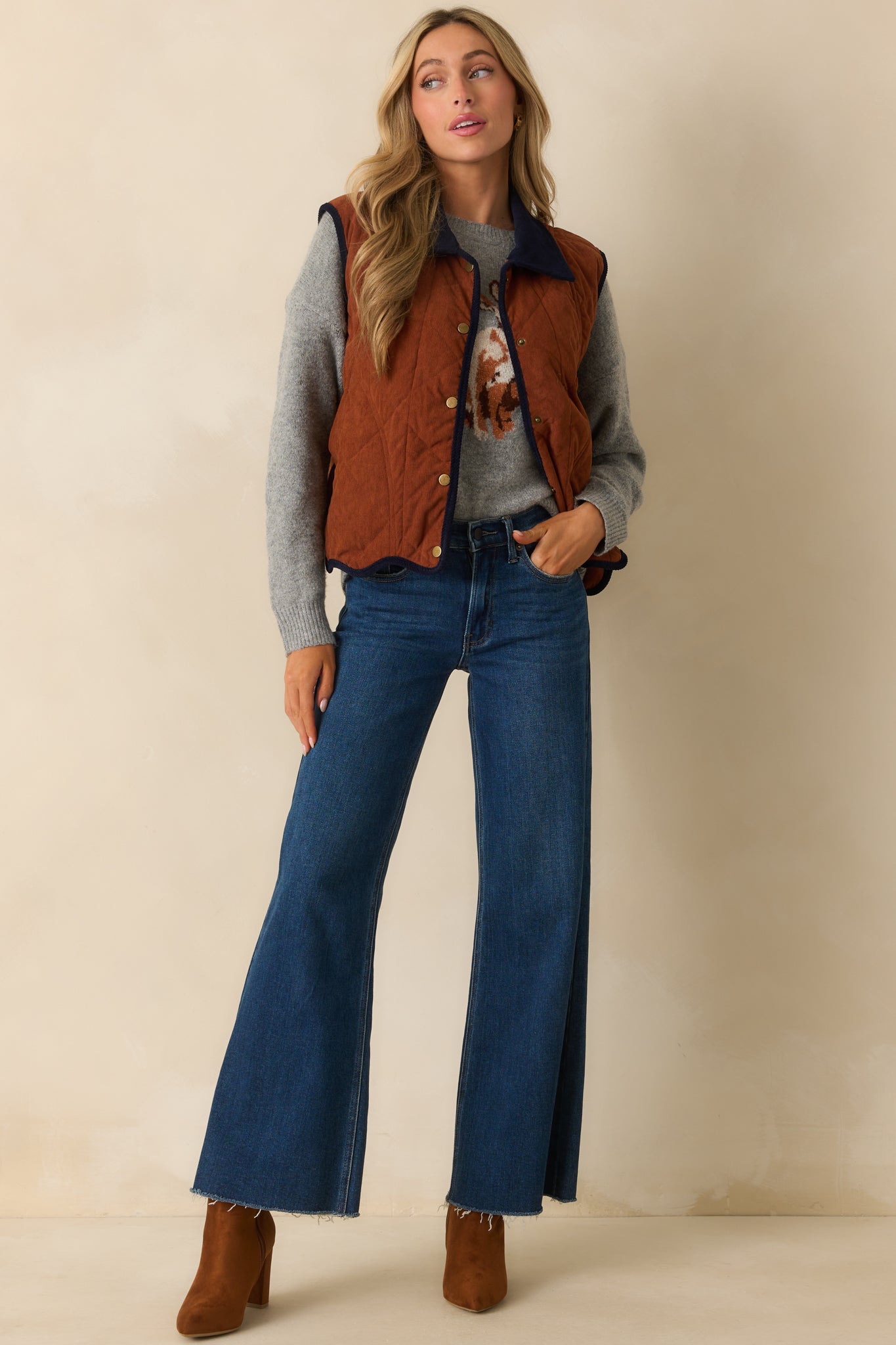 Vest featuring functional snap button front closure and scalloped hemline.