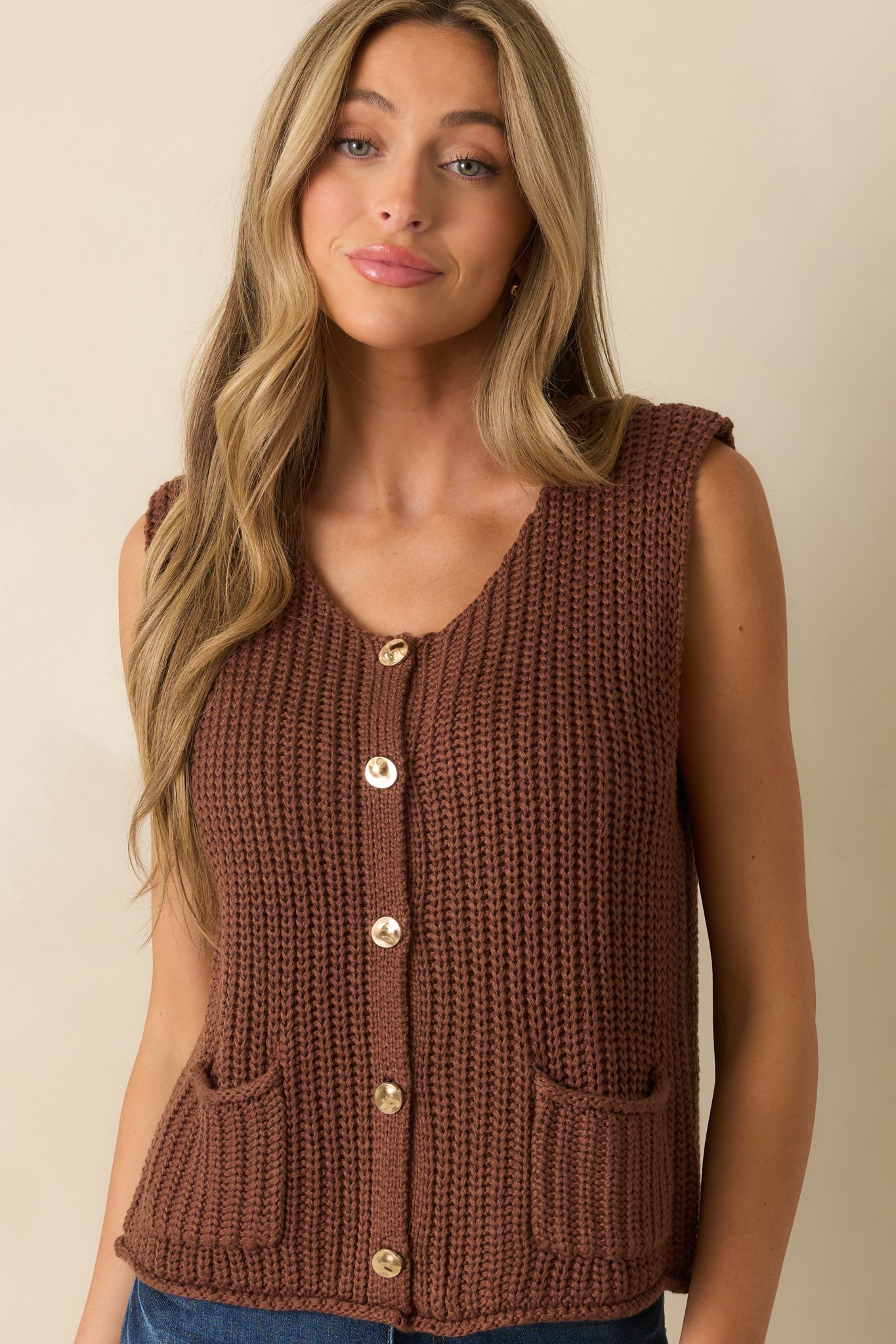 Cropped lower half view featuring the straight hemline and ribbed texture near the waist of the vest.
