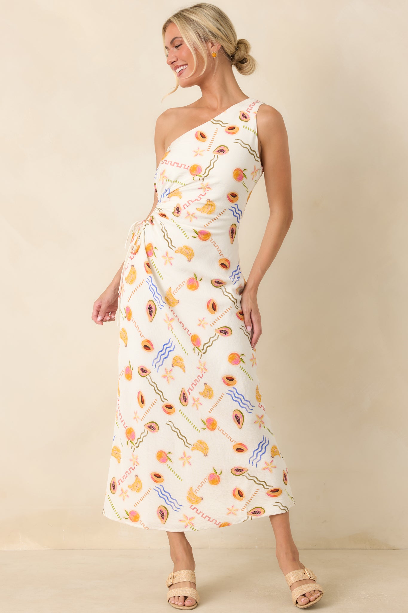 Viscose blend maxi dress with a vibrant fruit print, side cutout detail, and elegant flowing shape.