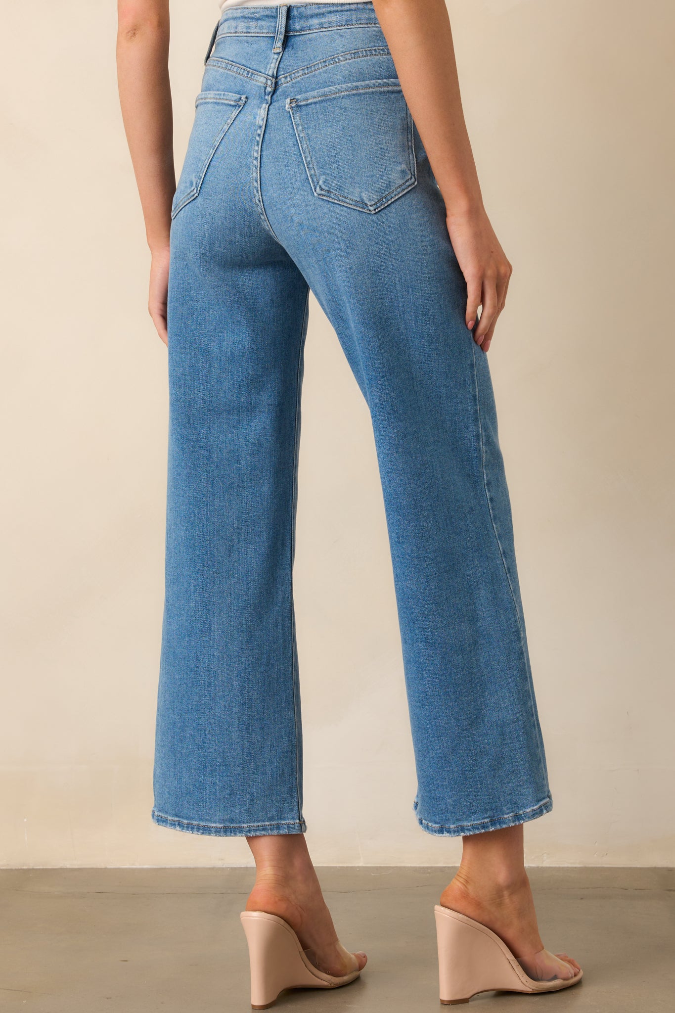 A view from behind of high-rise jeans with functional back pockets and wide leg fit.