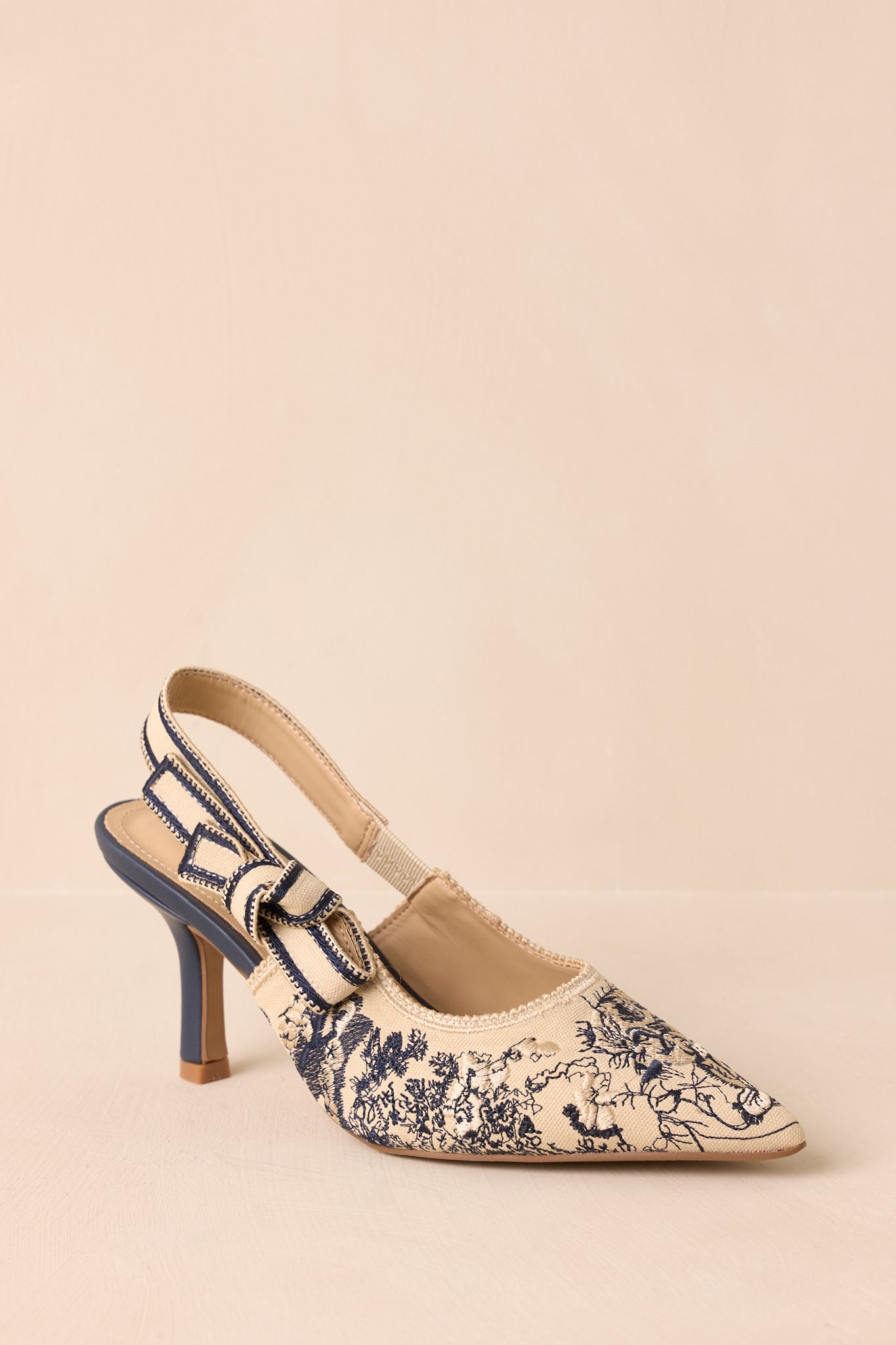 Angled view highlighting the embroidered contrast detailing and elegant structured shape.