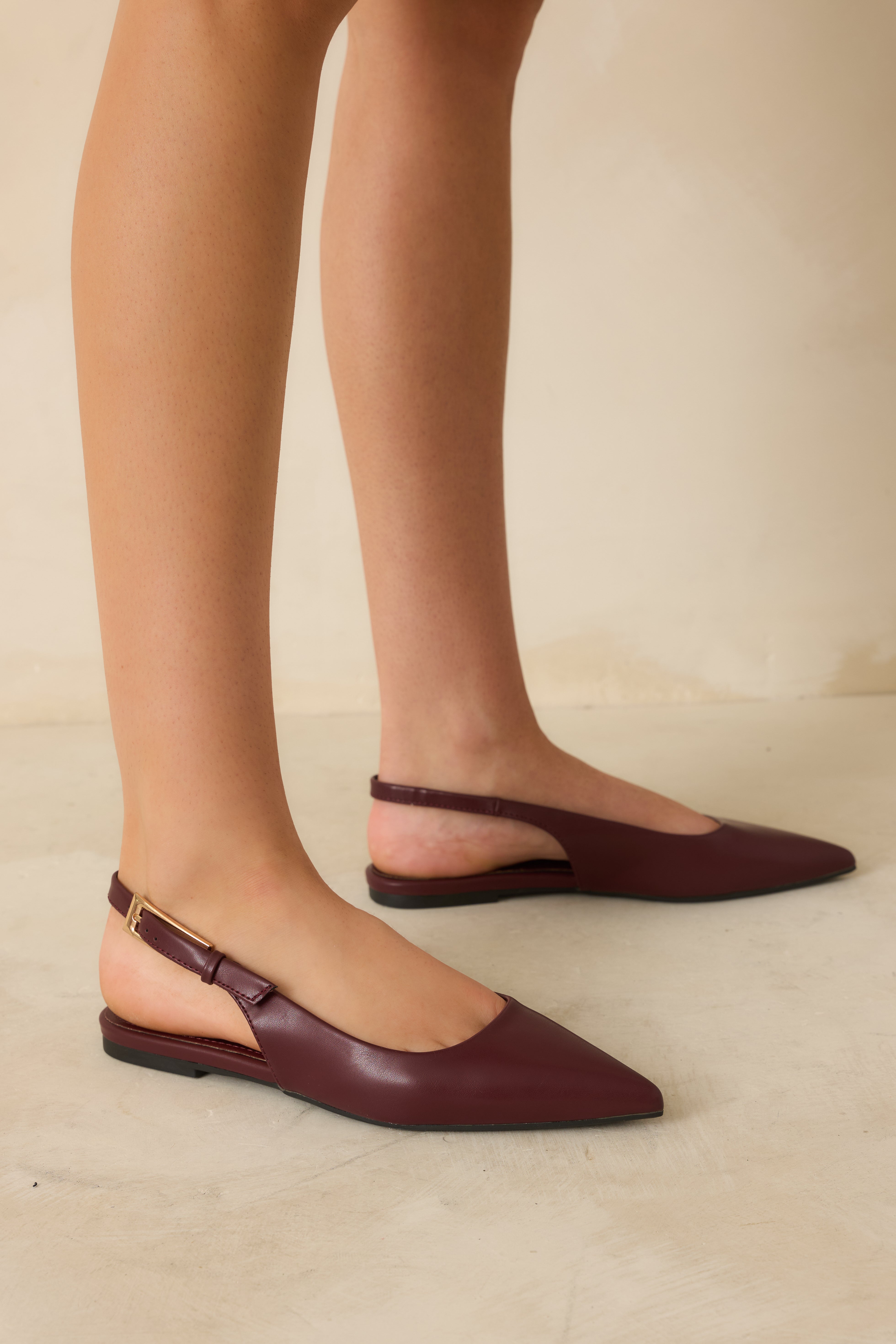 Front angled view of wine red slingback flats highlighting the pointed toe and smooth faux-leather finish.