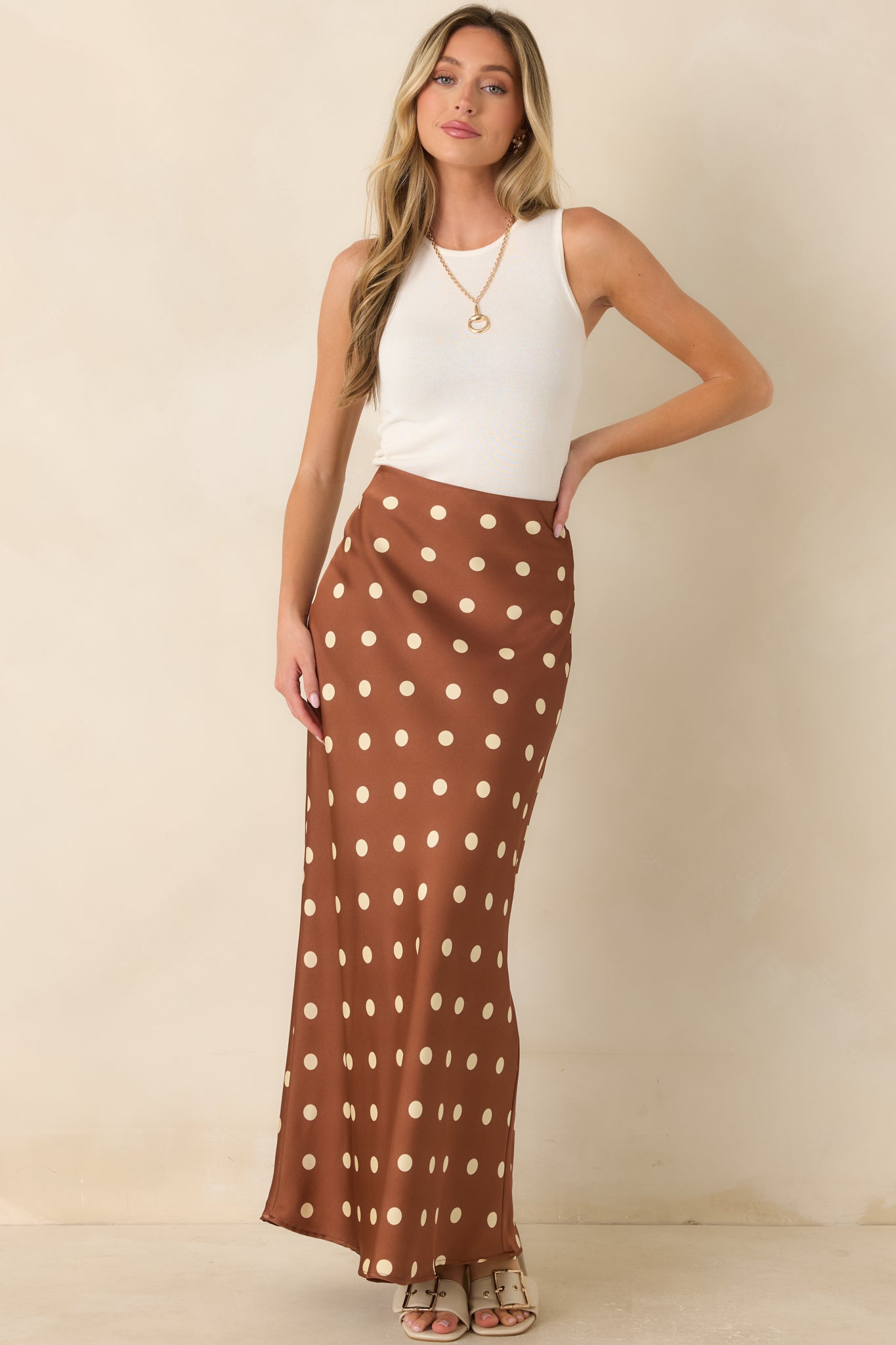 Vintage-inspired brown satin maxi skirt featuring ivory polka dots, a flowing bias-cut shape, and polished drape.
