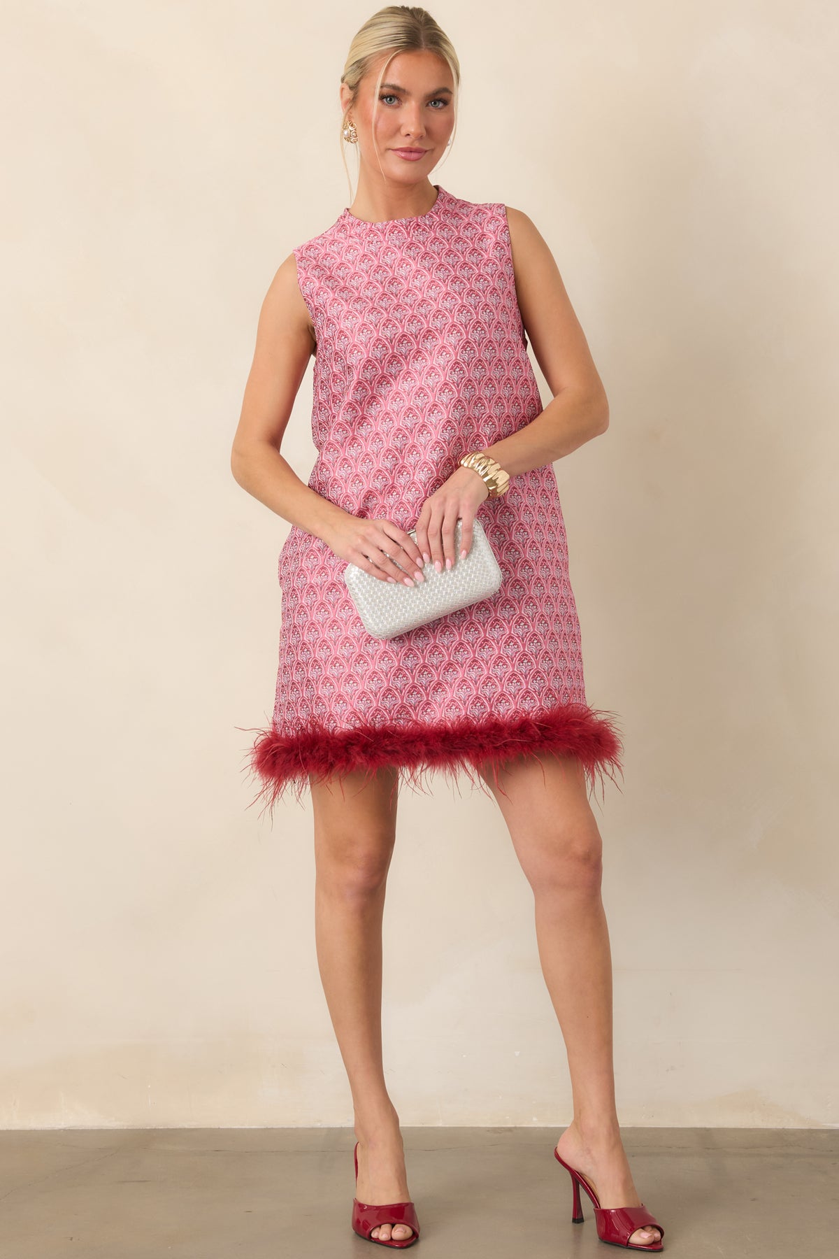 Vintage-inspired floral mini dress with a sleeveless design, high neckline, and wispy burgundy feather detailing.