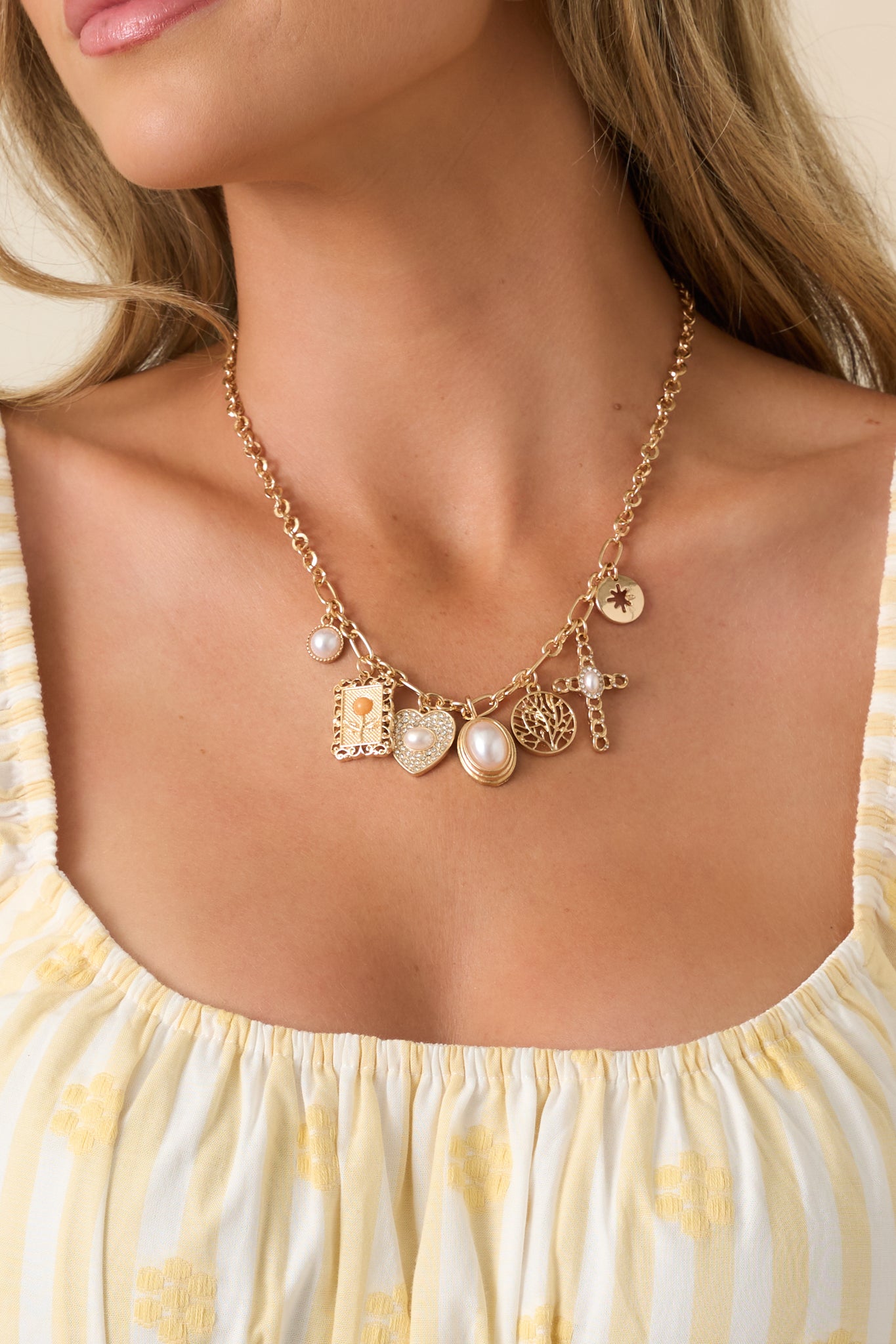 Vintage-inspired gold necklace showcasing delicate charms, crystal accents, and a layered collected design.