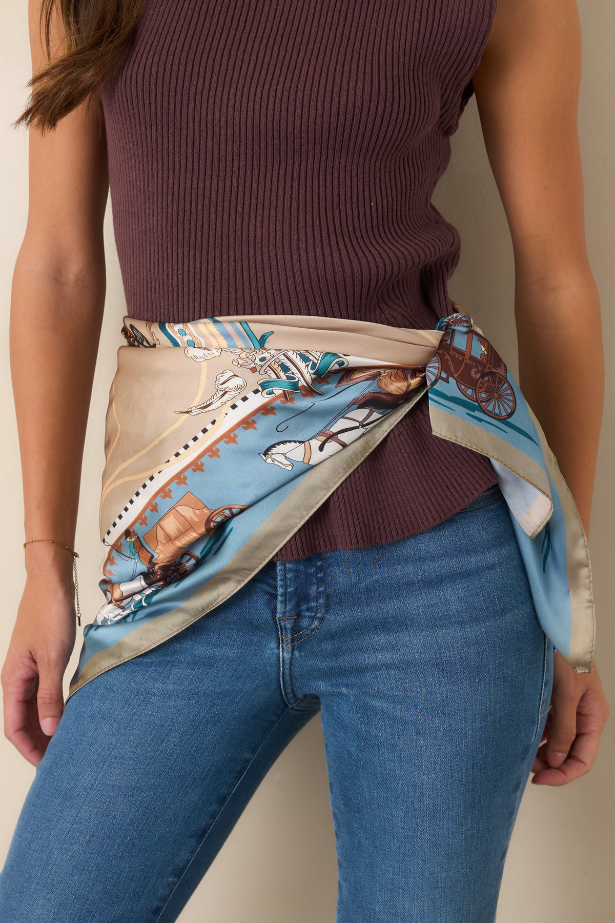 Vintage-inspired hair scarf featuring horse-drawn carriages and ornate motifs in dusty blue, taupe, cream, and brown.