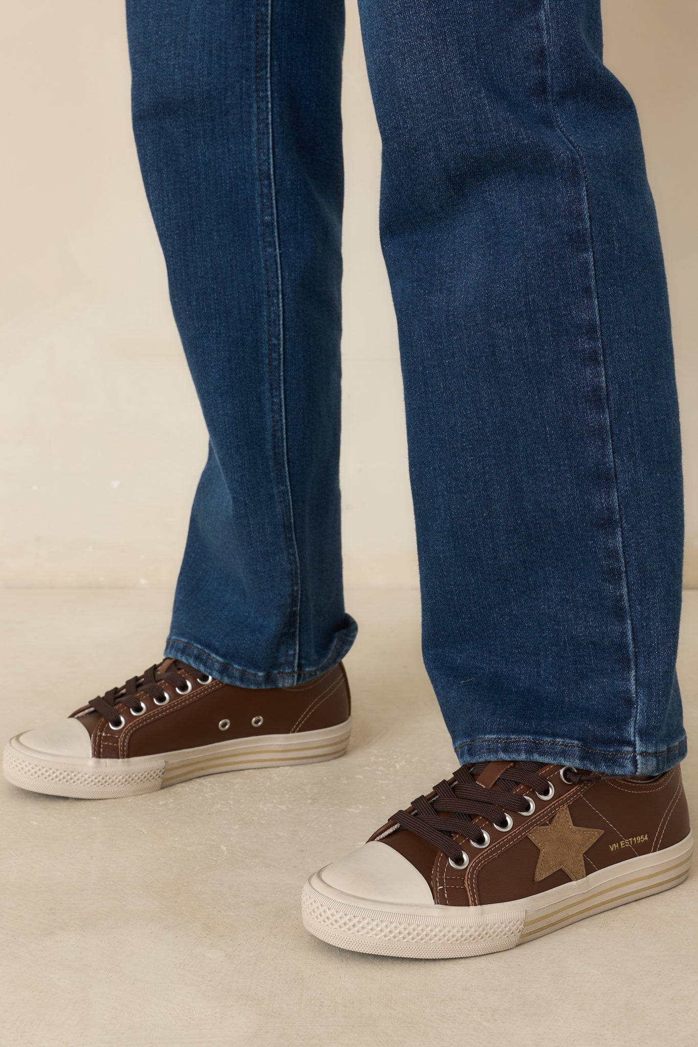 Vintage-inspired sneakers showcasing a rich brown upper, contrast stitching, textured panels, and a classic rubber sole design.