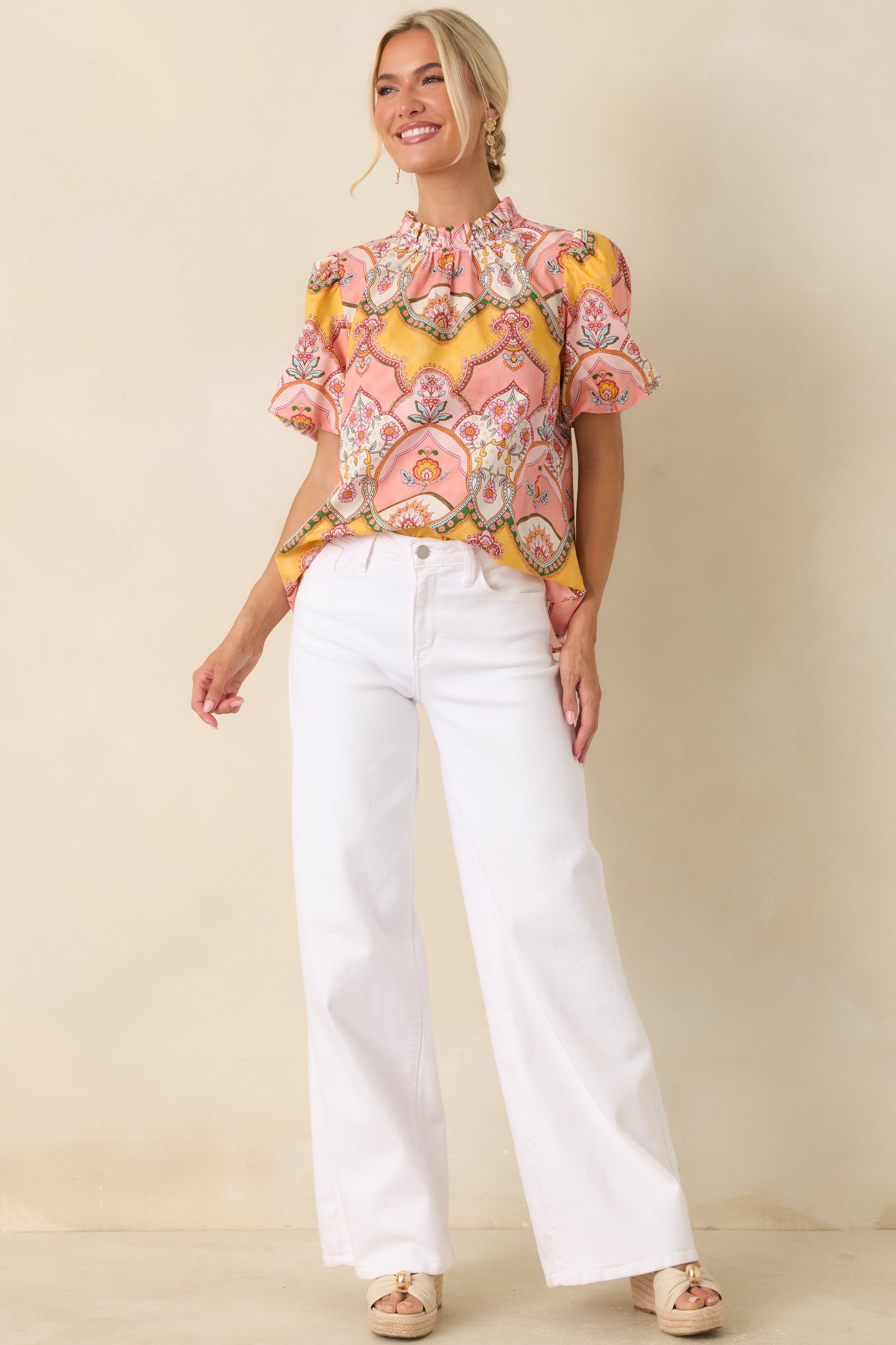 Vintage-inspired ornamental print top featuring a ruffled mock neckline and vibrant mixed-print detailing throughout the cotton fabric.