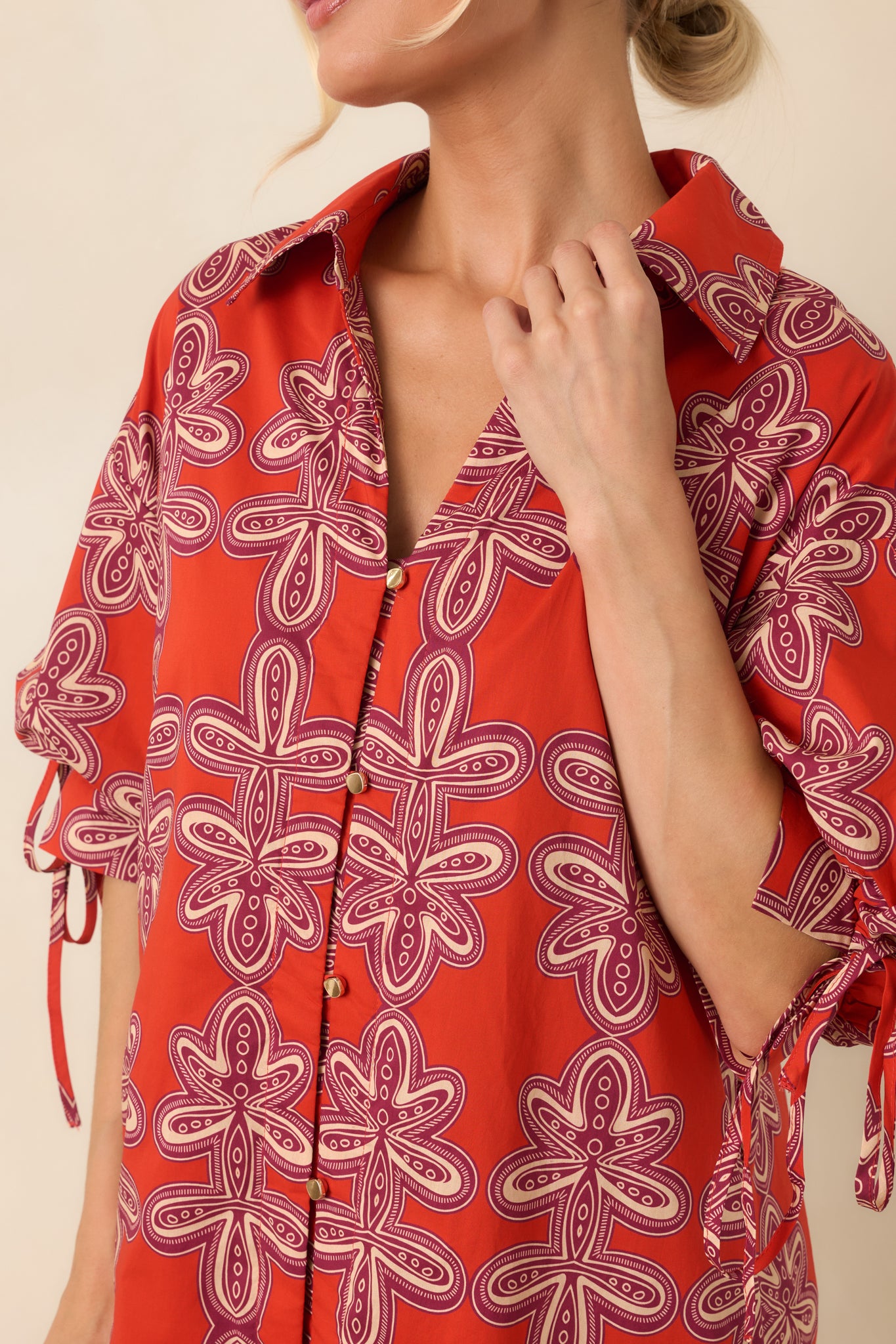 Close-up of the vintage-inspired print, collared neckline, functional buttons, and tie-detail puff sleeve construction.
