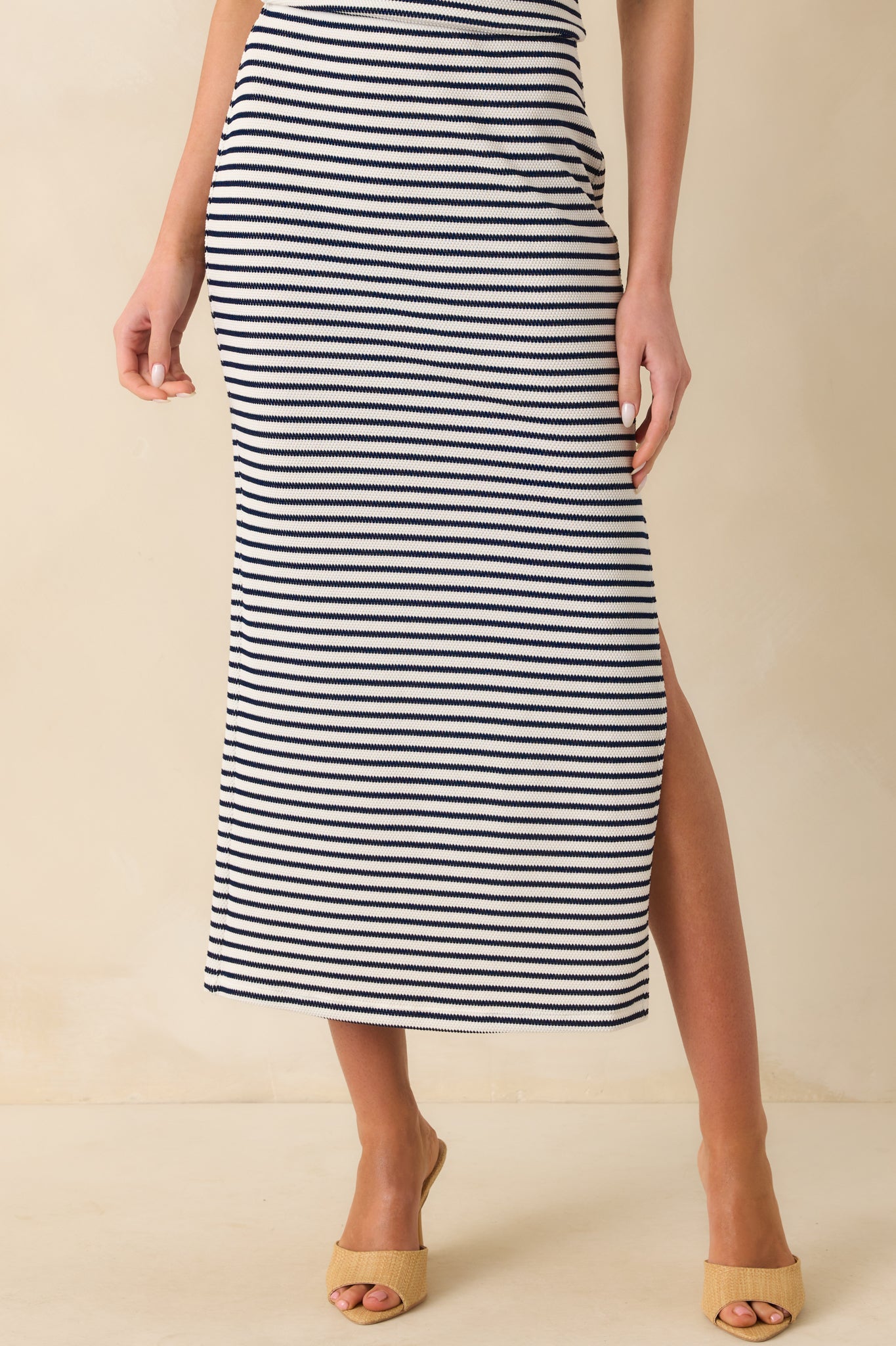 A cropped waist-down view emphasizing the leg slit opening and the stretch of the knit fabric across the hips.