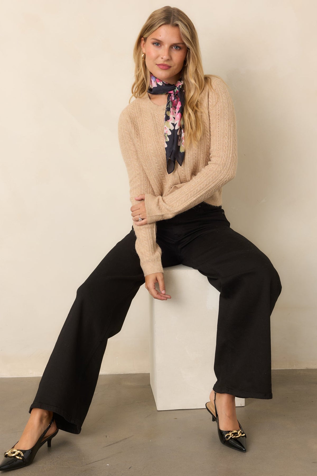 Warm beige cardigan featuring delicate cable-knit detailing, a classic crew neckline, and softly fitted silhouette.