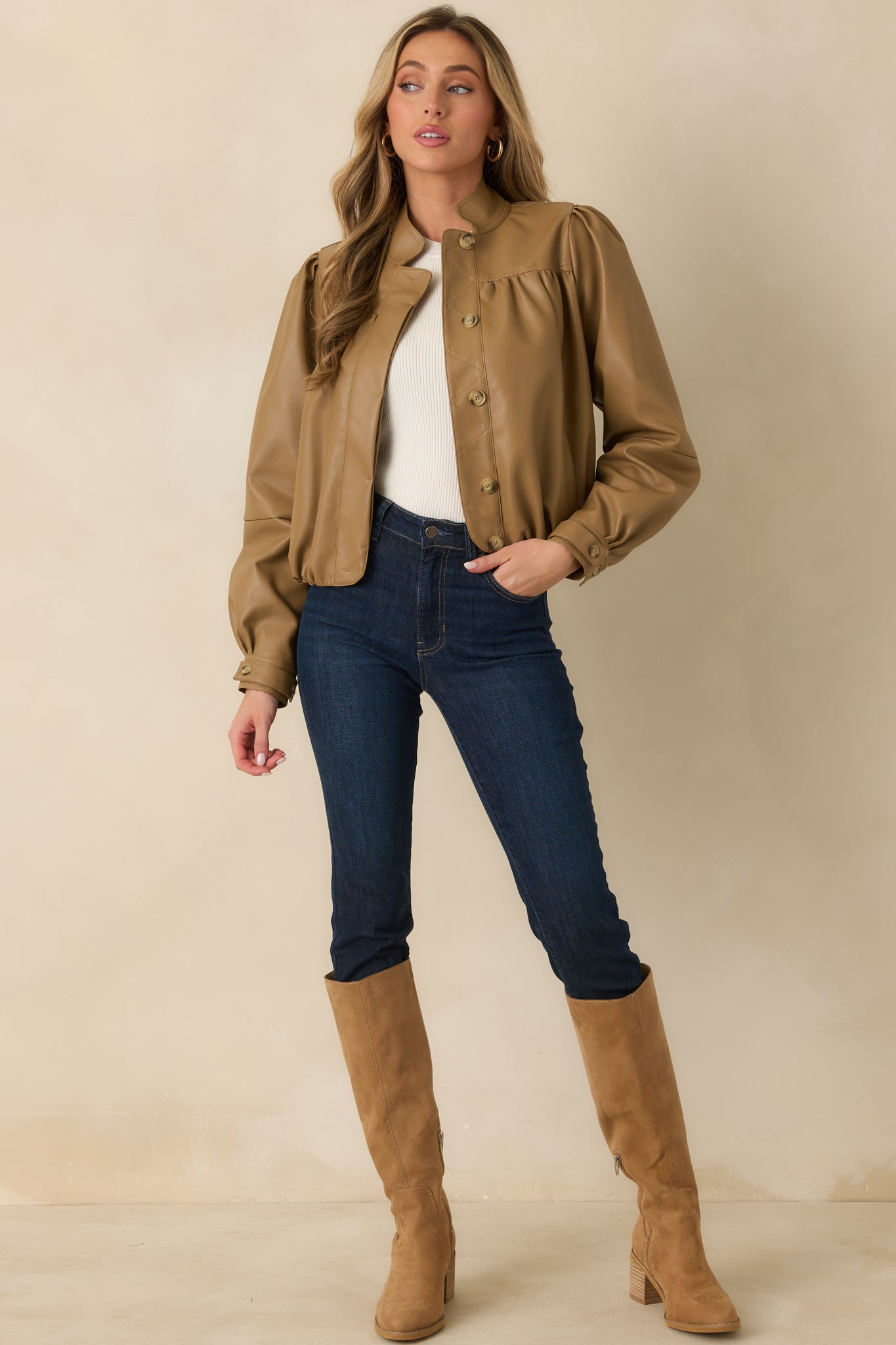 Warm caramel jacket showcasing gathered detailing along the front yoke, geometric quilted stitching, and a waist-length silhouette.