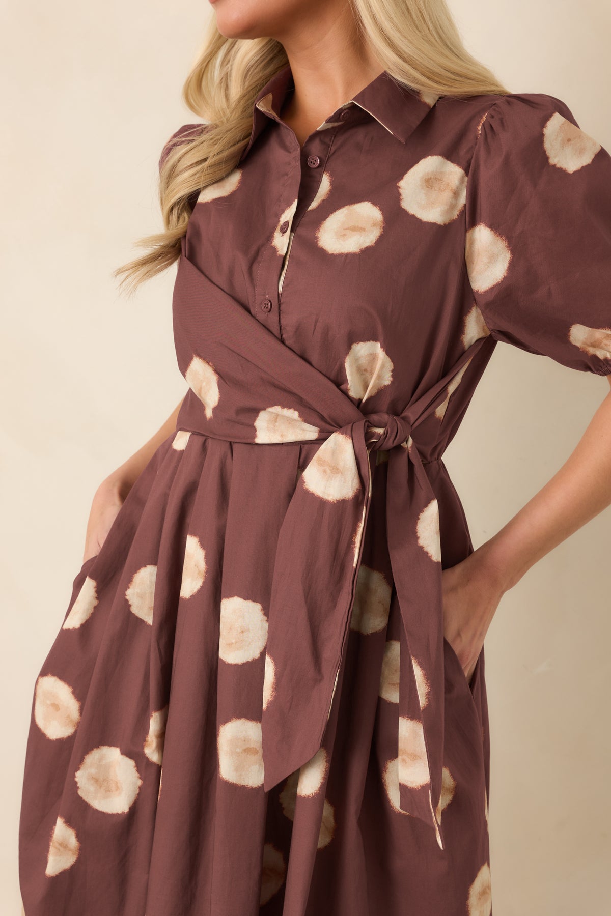 Warm earthy dress highlighting the collared neckline, functional buttons, and wrap-inspired side tie.