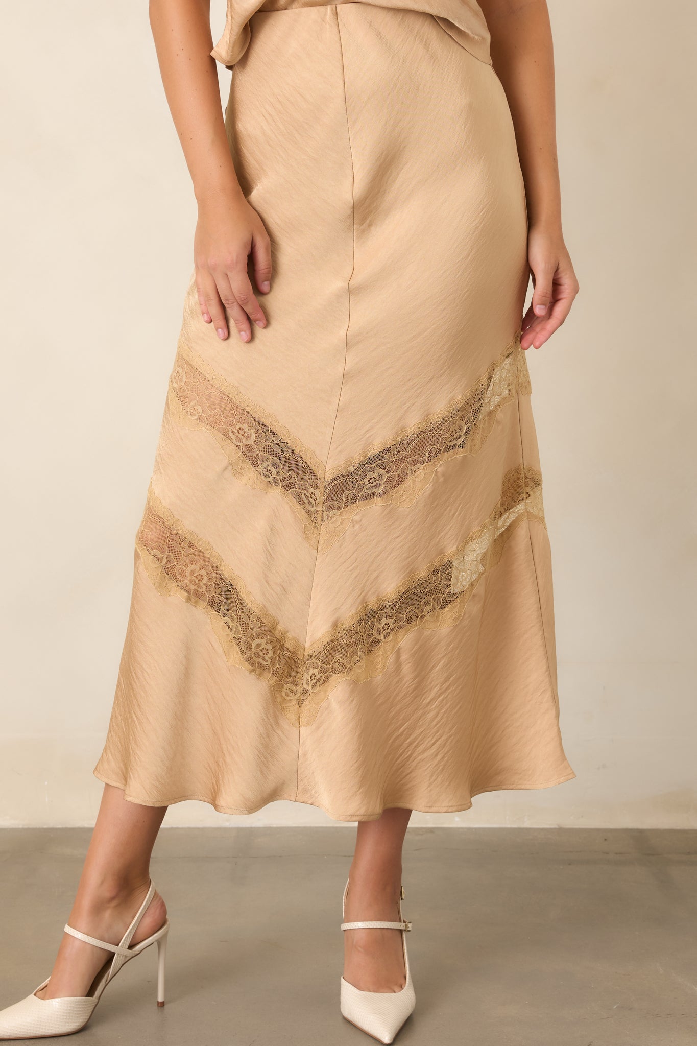 Warm tan skirt showcasing its clean silhouette, textured finish, and feminine angled lace insets.