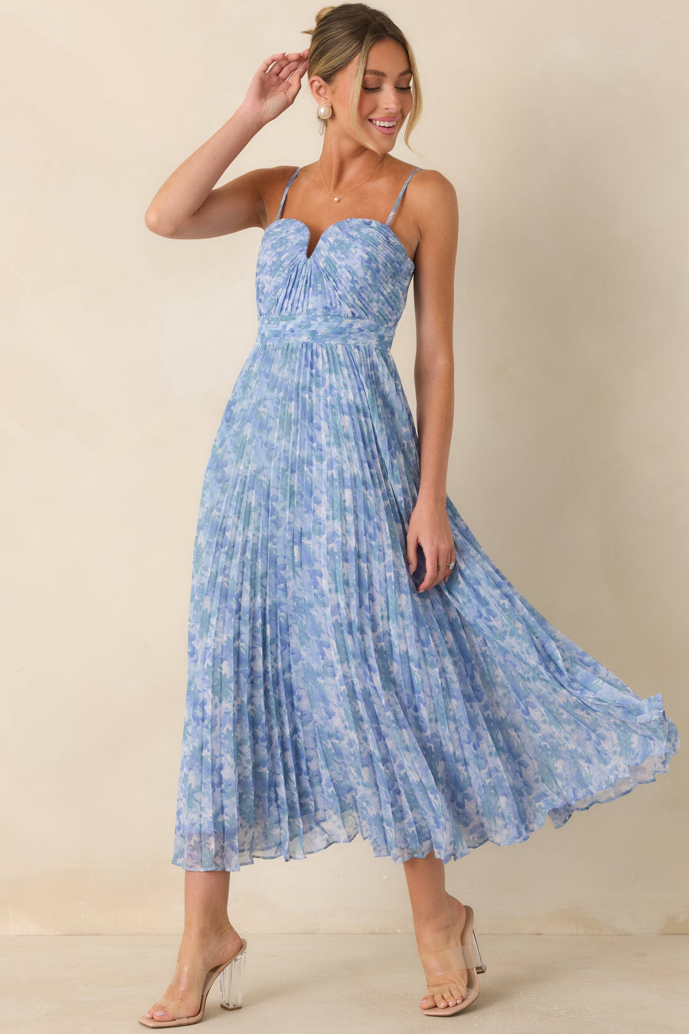 Watercolor-inspired floral maxi dress highlighting adjustable straps, a fitted bodice, and an elegant silhouette.