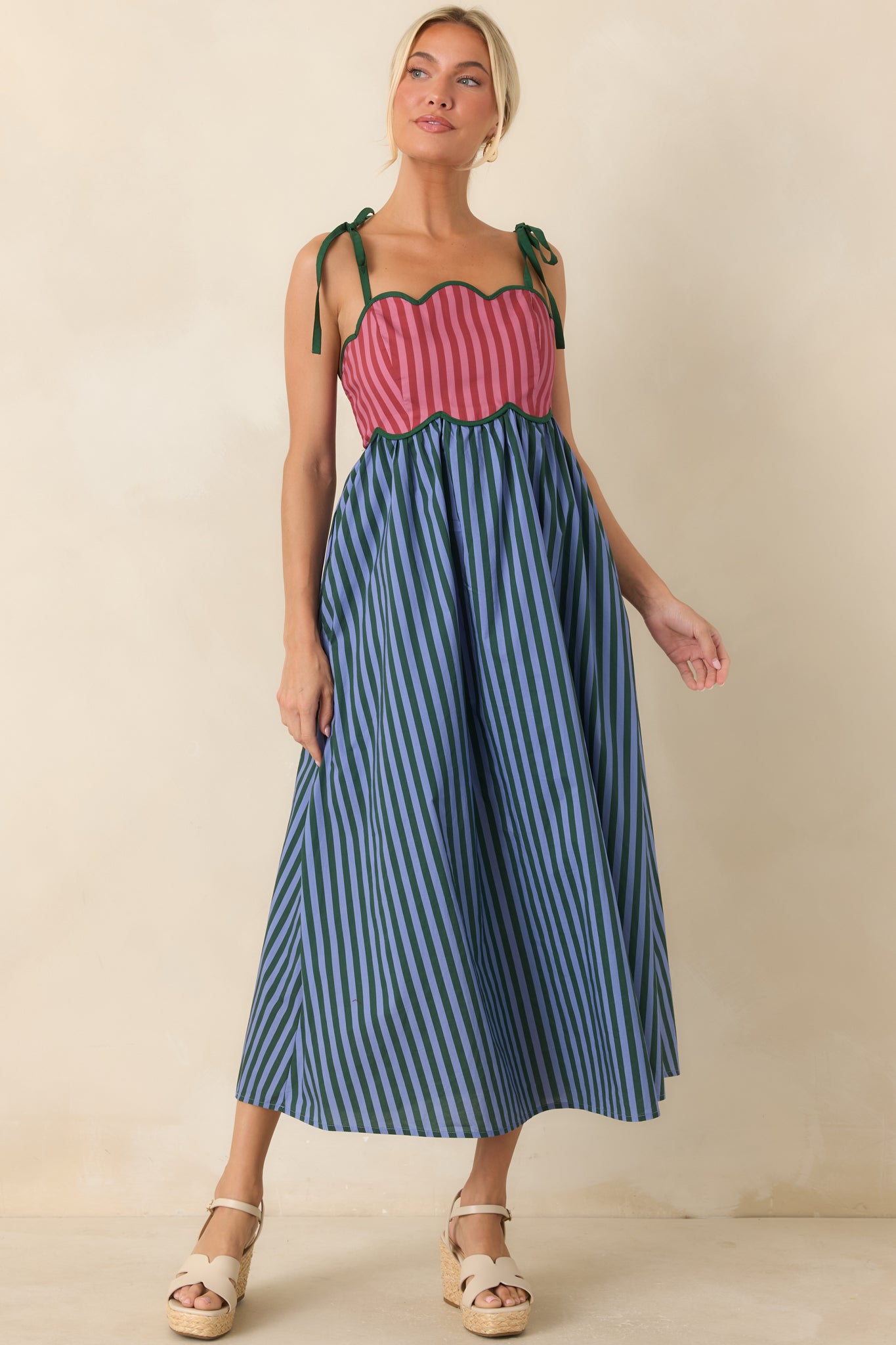 Whimsical striped midi dress showcasing a scalloped bodice, rosy hues, and a playful full skirt design.