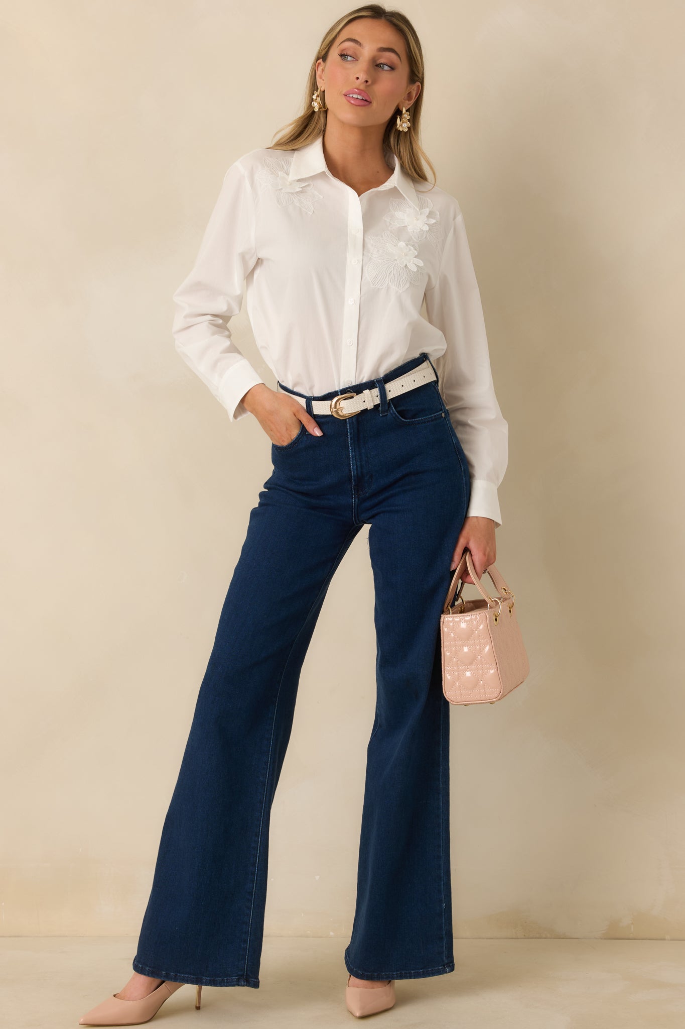 Classic white button-down blouse with floral appliqué trim displayed front-facing, showing its easy, draped fit.