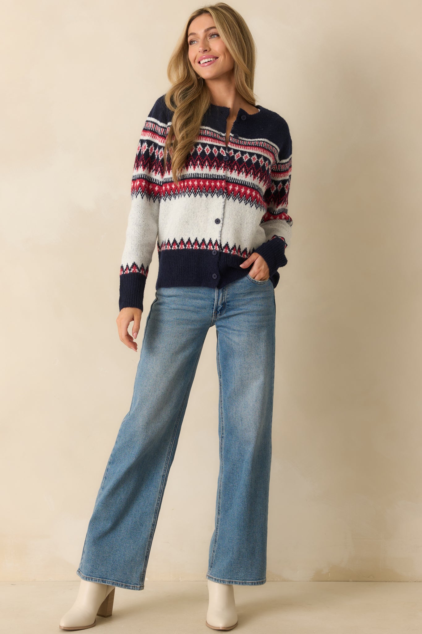 Cozy white cardigan with navy and red Fair Isle detailing, long sleeves, and button-front closure.