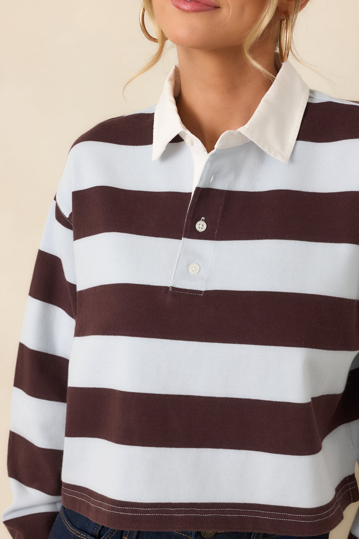 Close-up of the white point collar, partial button placket, and striped fabric.