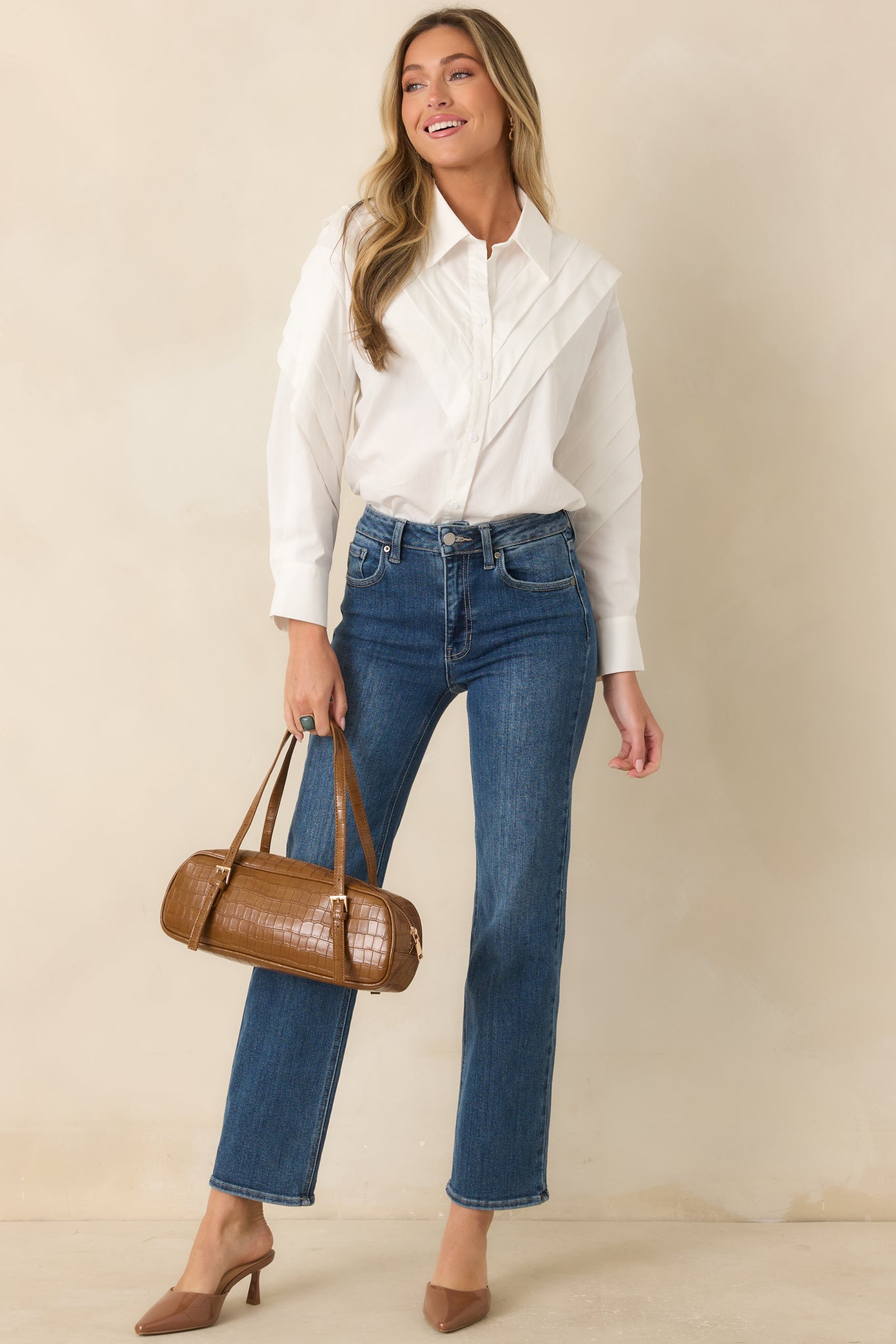 Cotton button-up top with architectural shoulder pleats, button cuffs, and a clean versatile design.