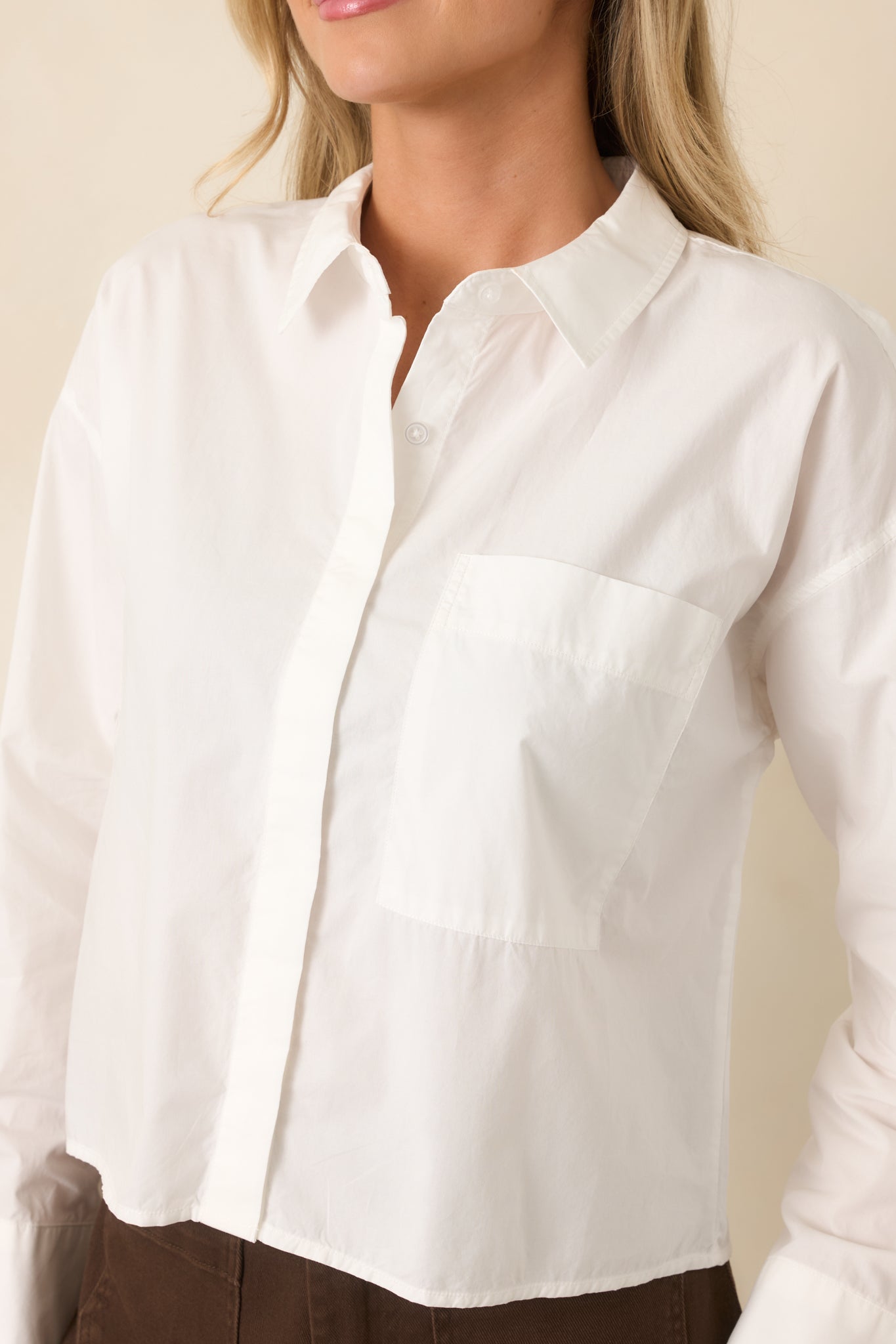Close-up of the white cotton fabric displaying the button details, smooth texture, and clean finish.