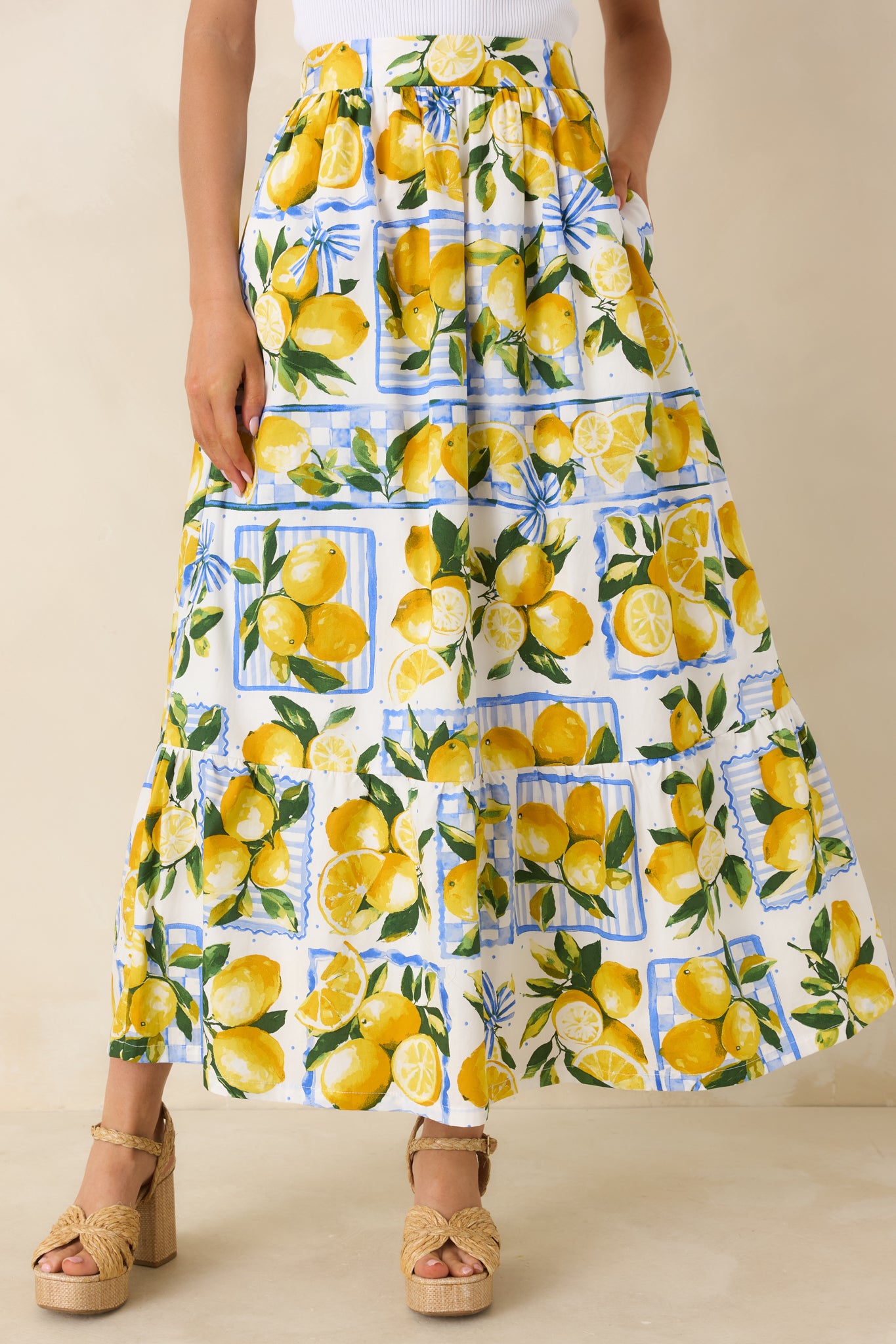 Tiered panel detailing on the white cotton skirt showcasing yellow lemons, leafy greenery, and soft blue accents.
