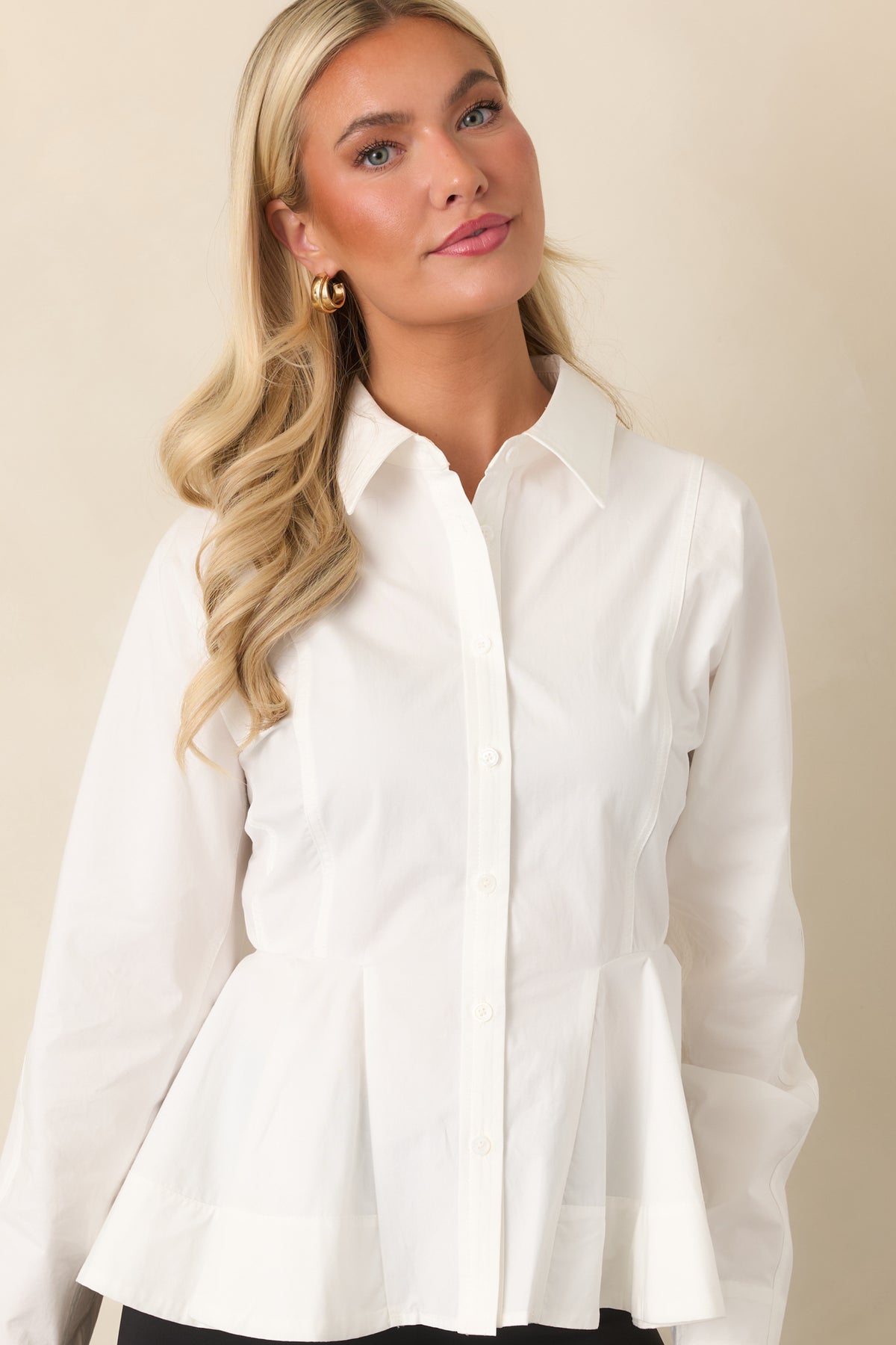White cotton top highlighting the collared neckline, front buttons, and waist-defining seam details.