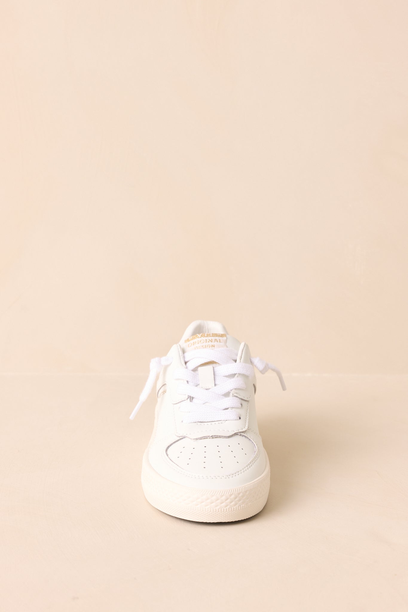 White hand-distressed leather sneakers with rubber platform sole shown from a front angle.