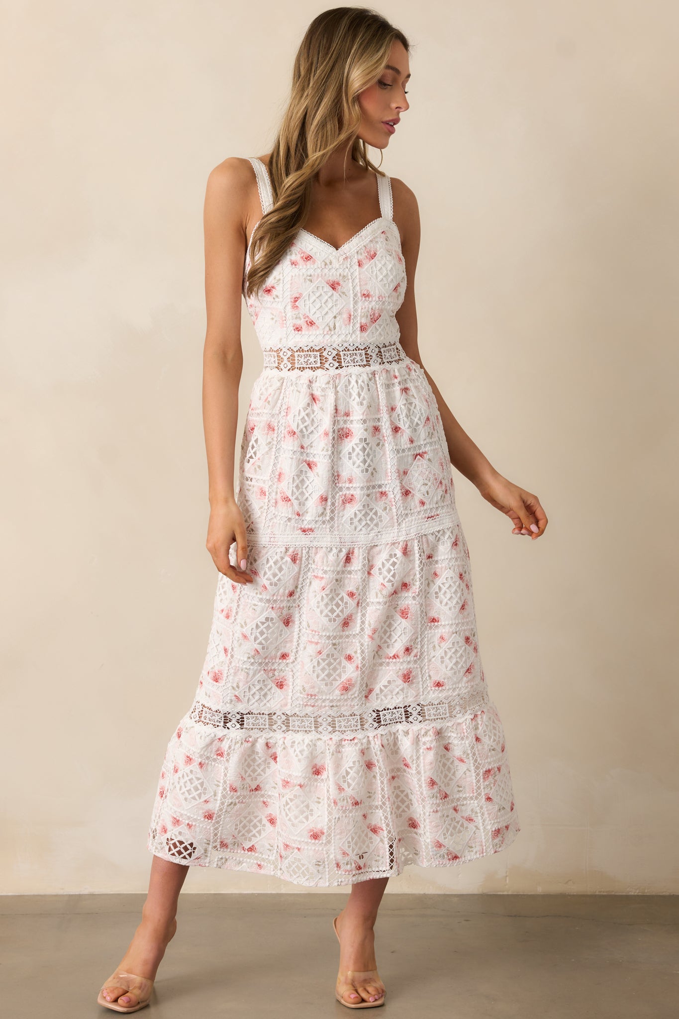 A classic white dress featuring a soft embroidered overlay, tiered skirt, and eyelet cutout details for a breezy feel.