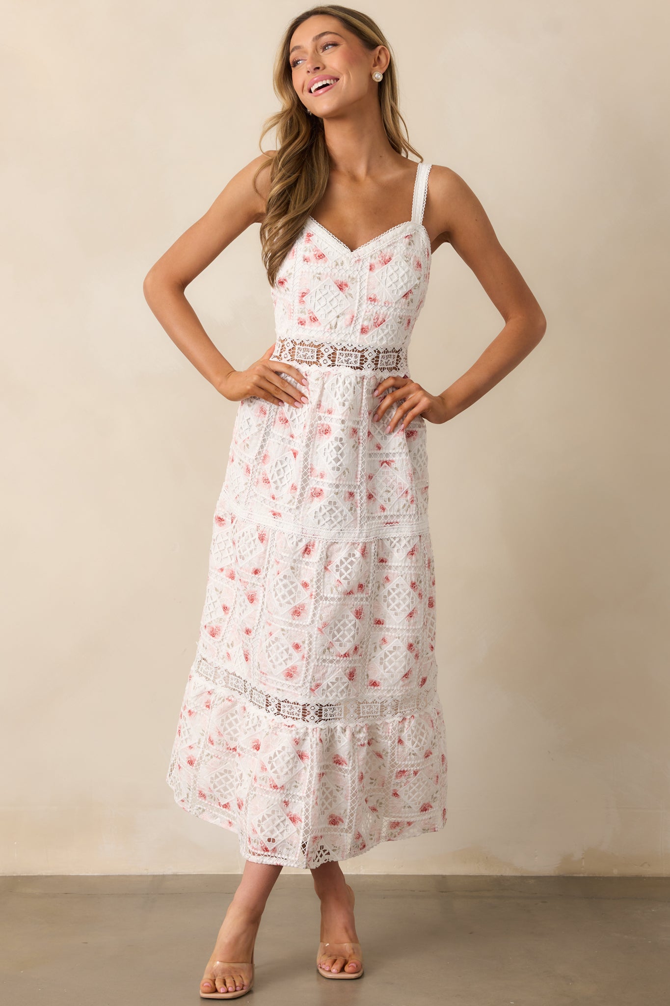 A feminine white dress with a tiered skirt, ladder trim waistline, and elegant eyelet embroidery throughout.