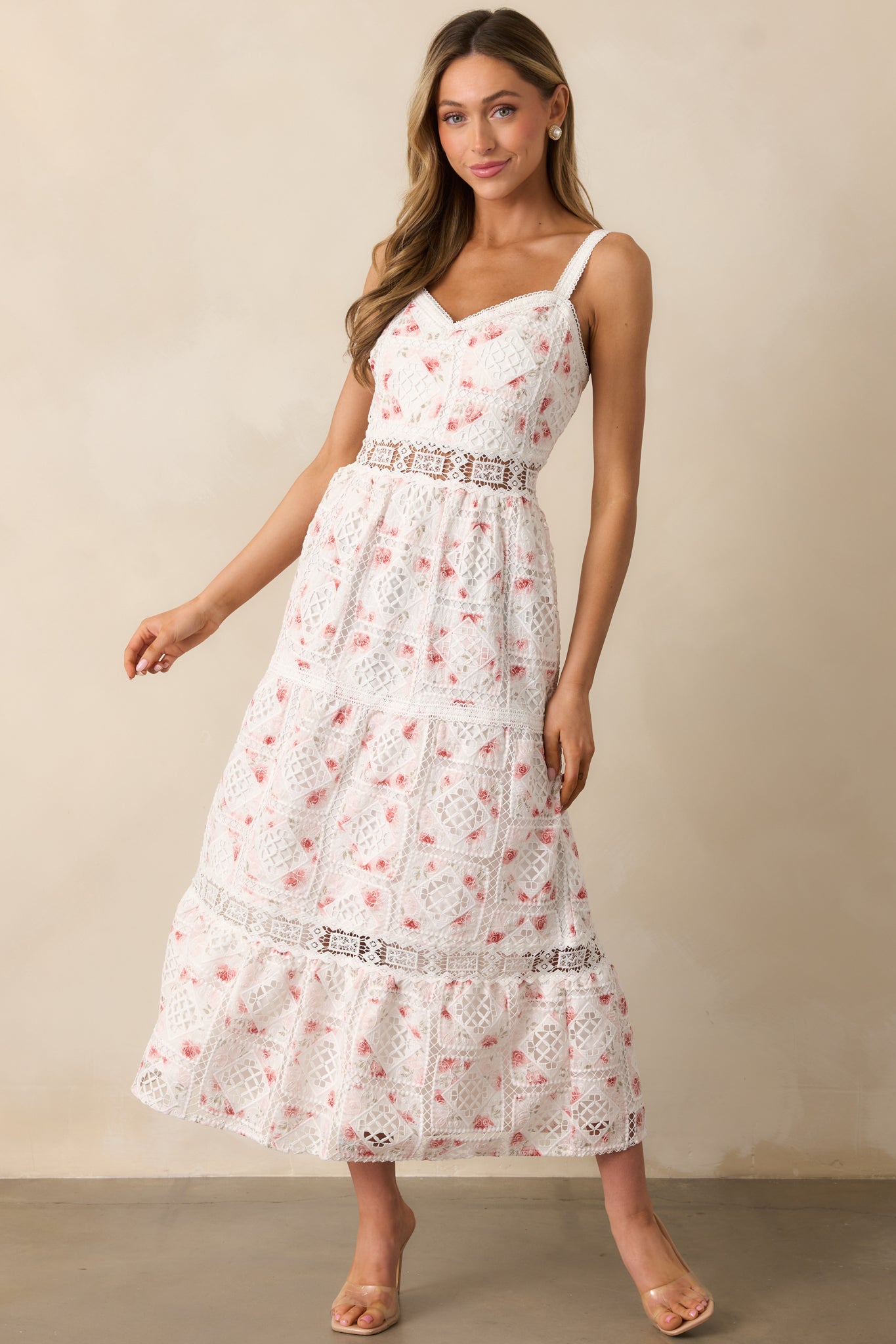 A stylish white dress showcasing a V-neckline, structured ladder trim waist, and flowing below-the-knee tiered skirt.