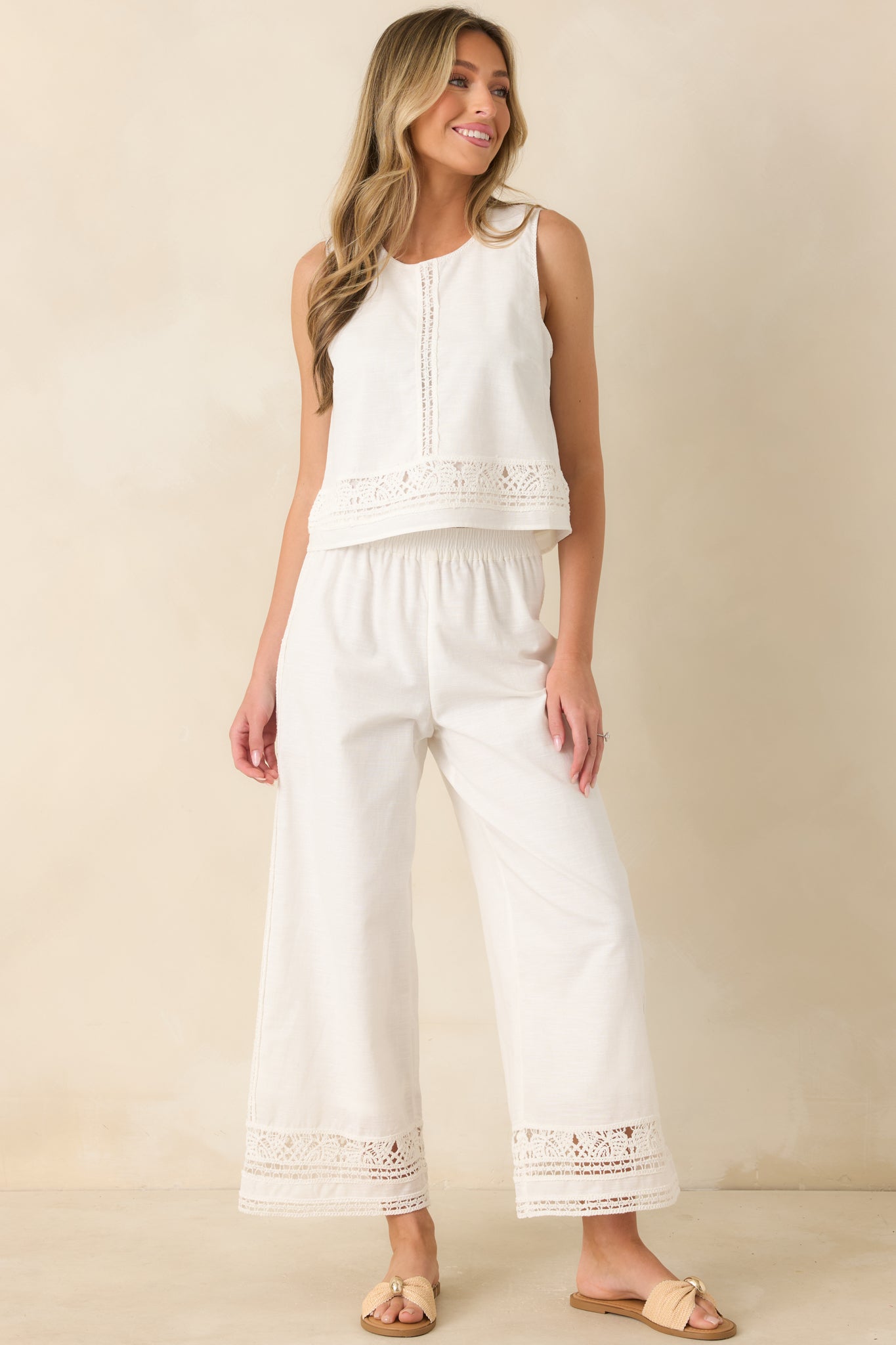White embroidered top showcasing a vertical inset panel, delicate crochet-inspired trim accents, and a classic round neckline.