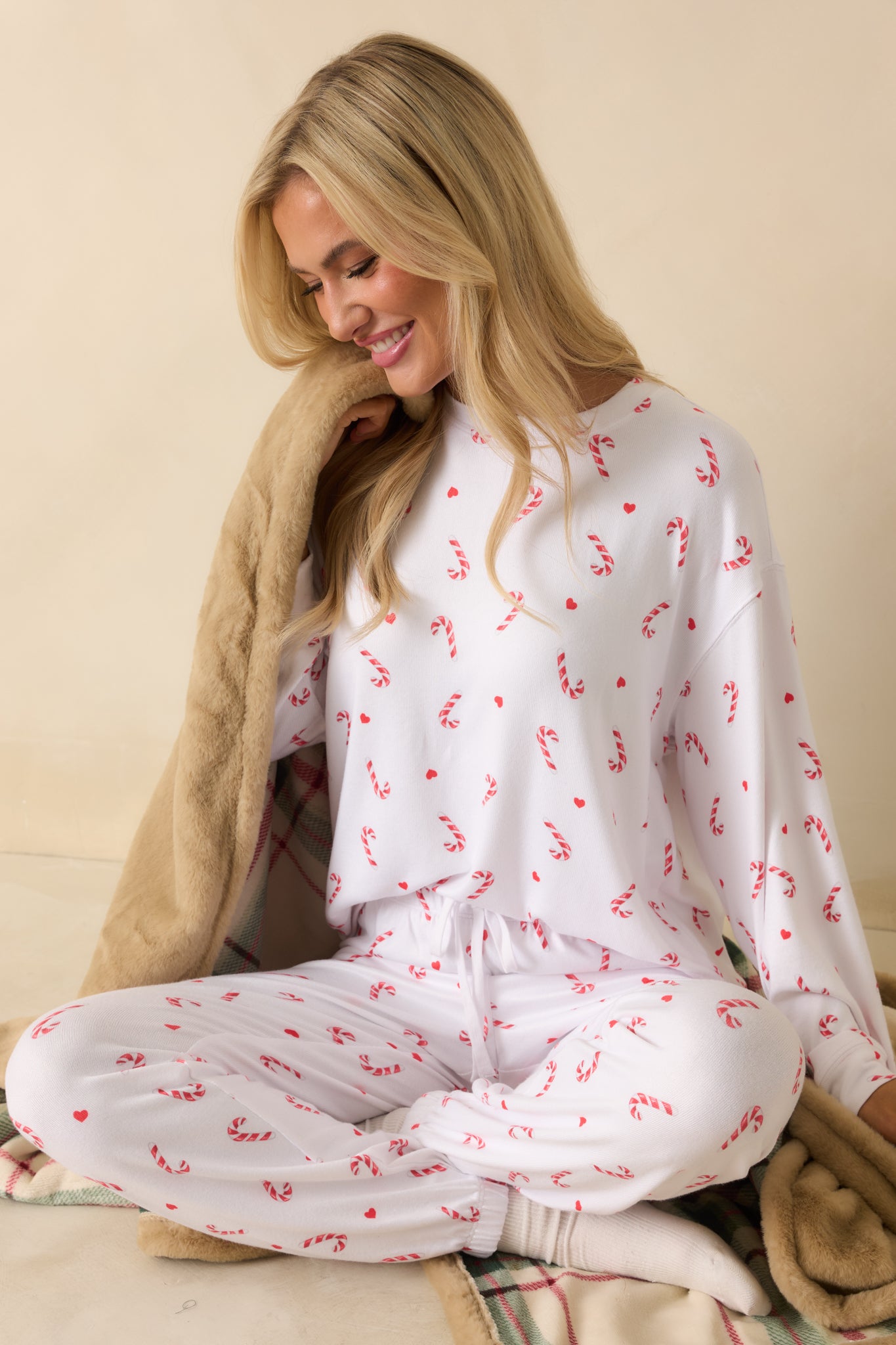 White festive top in soft jersey with crew neckline, long sleeves, and full candy-cane pattern for a cheerful holiday look.