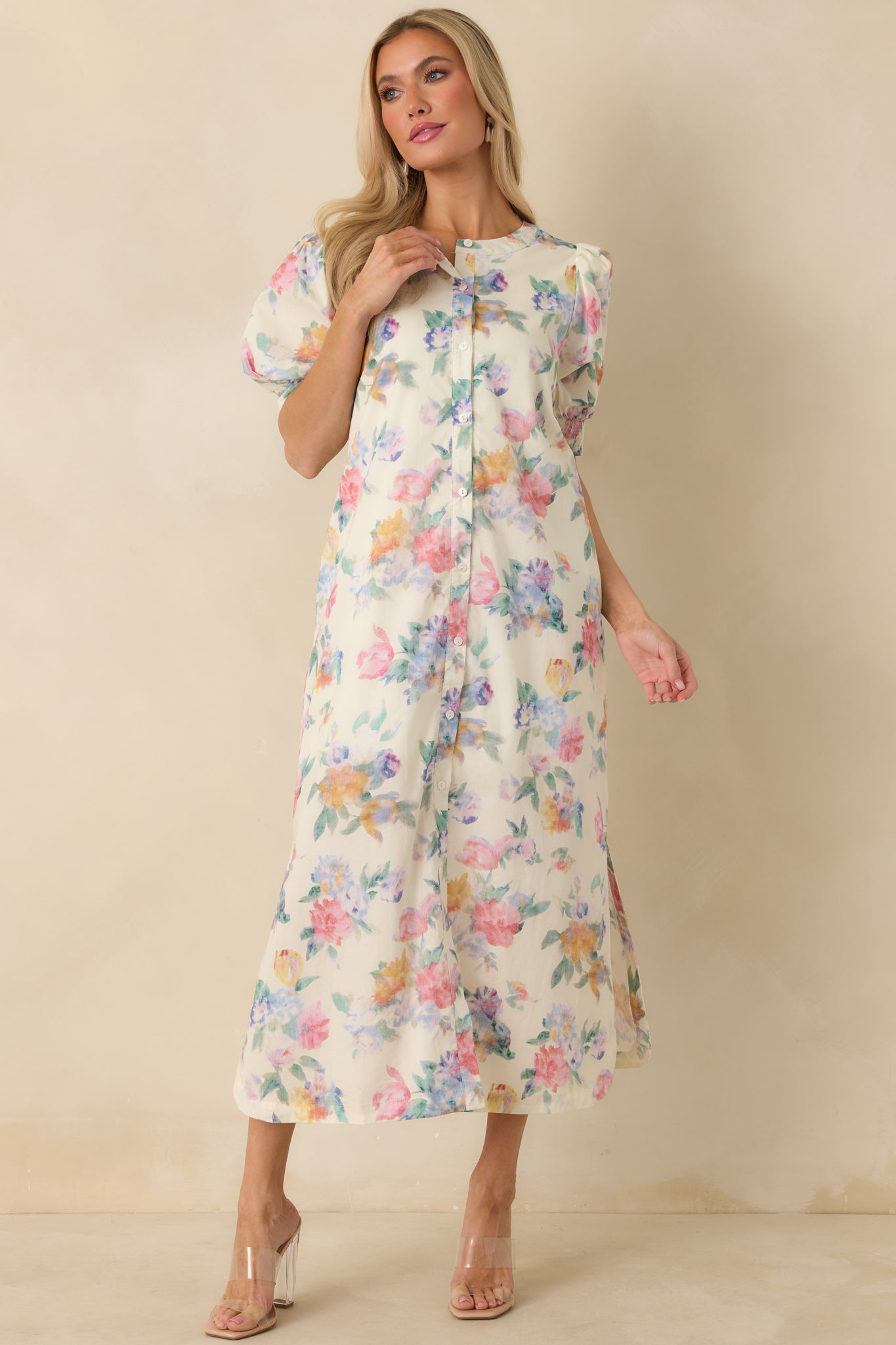 Front view of white floral maxi dress featuring full button-down front, puff sleeves, and maxi-length hem with side slits.
