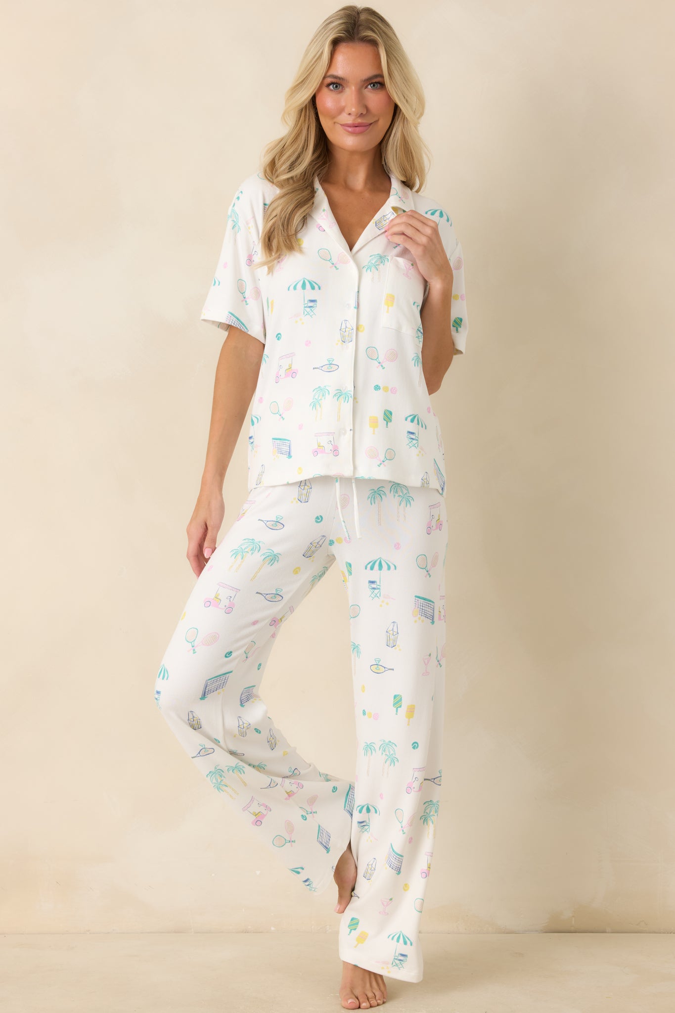 White pajama top in soft jersey knit featuring a collared neckline, short sleeves, and a relaxed button-front silhouette with an allover resort-inspired print.