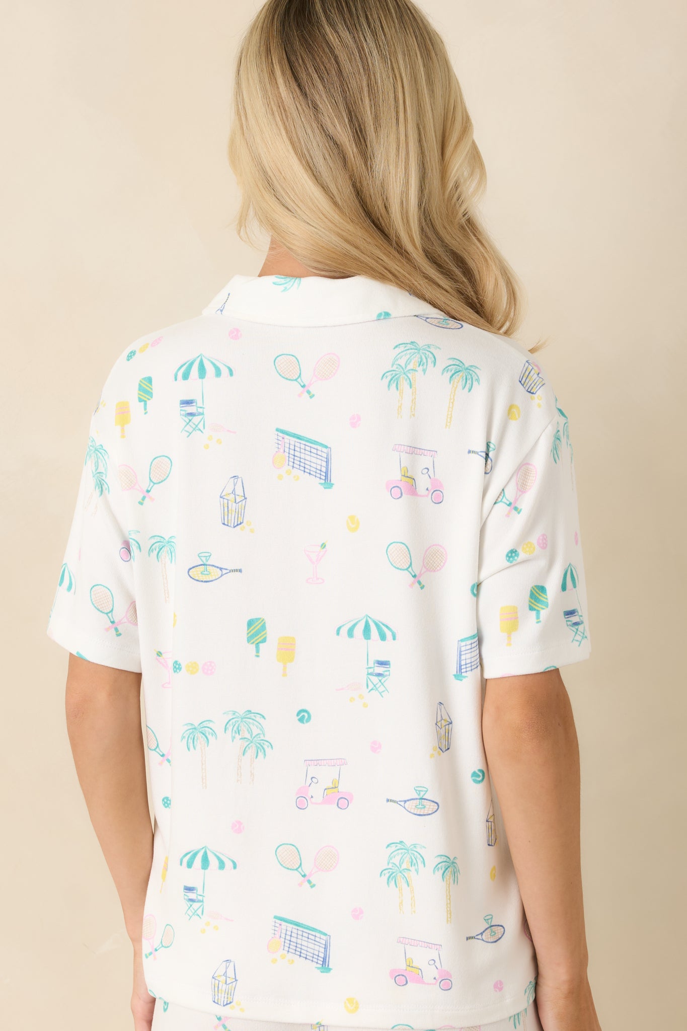 Back view of the white pajama top featuring short sleeves, a relaxed fit, and continuous allover printed design.