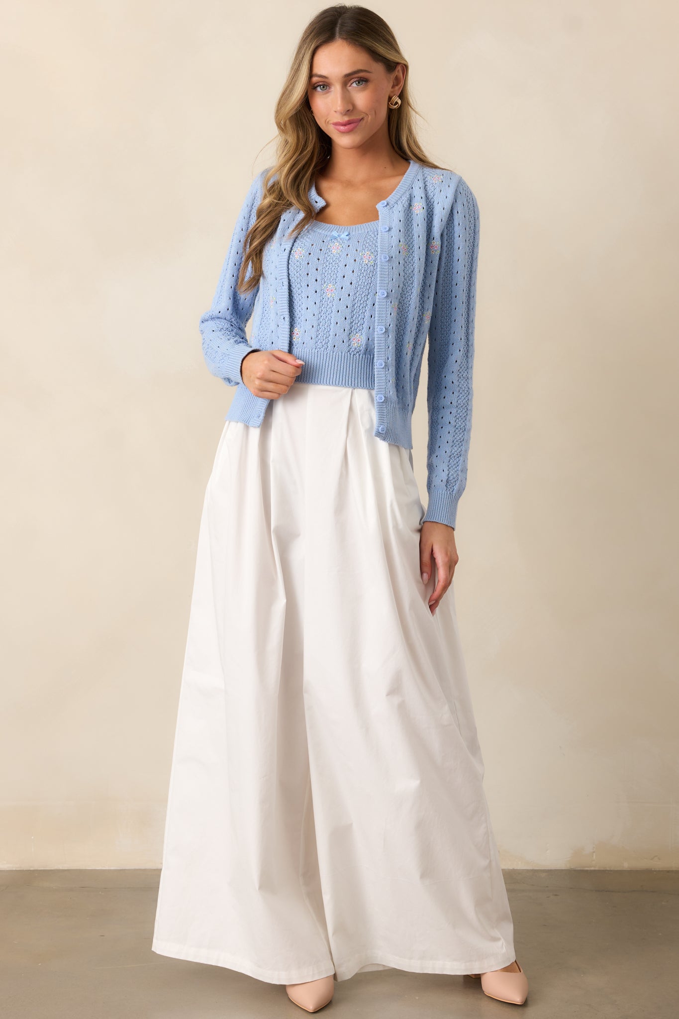Another full-body shot of the wide-leg white pants showcasing the pleated detailing at the waist which creates a structured yet relaxed silhouette.