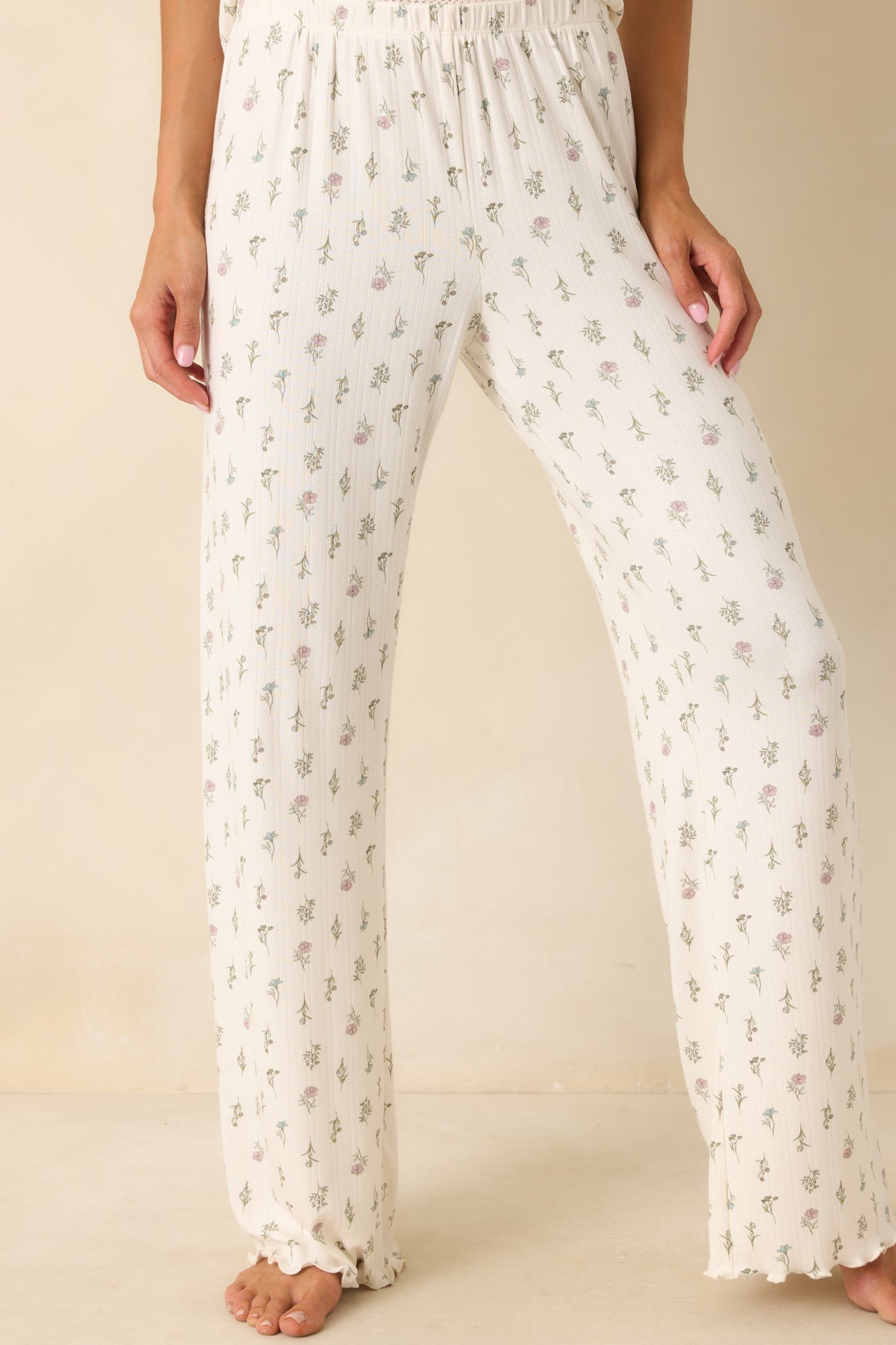 Zoomed view of the pant legs, showing the lightweight pointelle knit texture and the vibrant floral design.