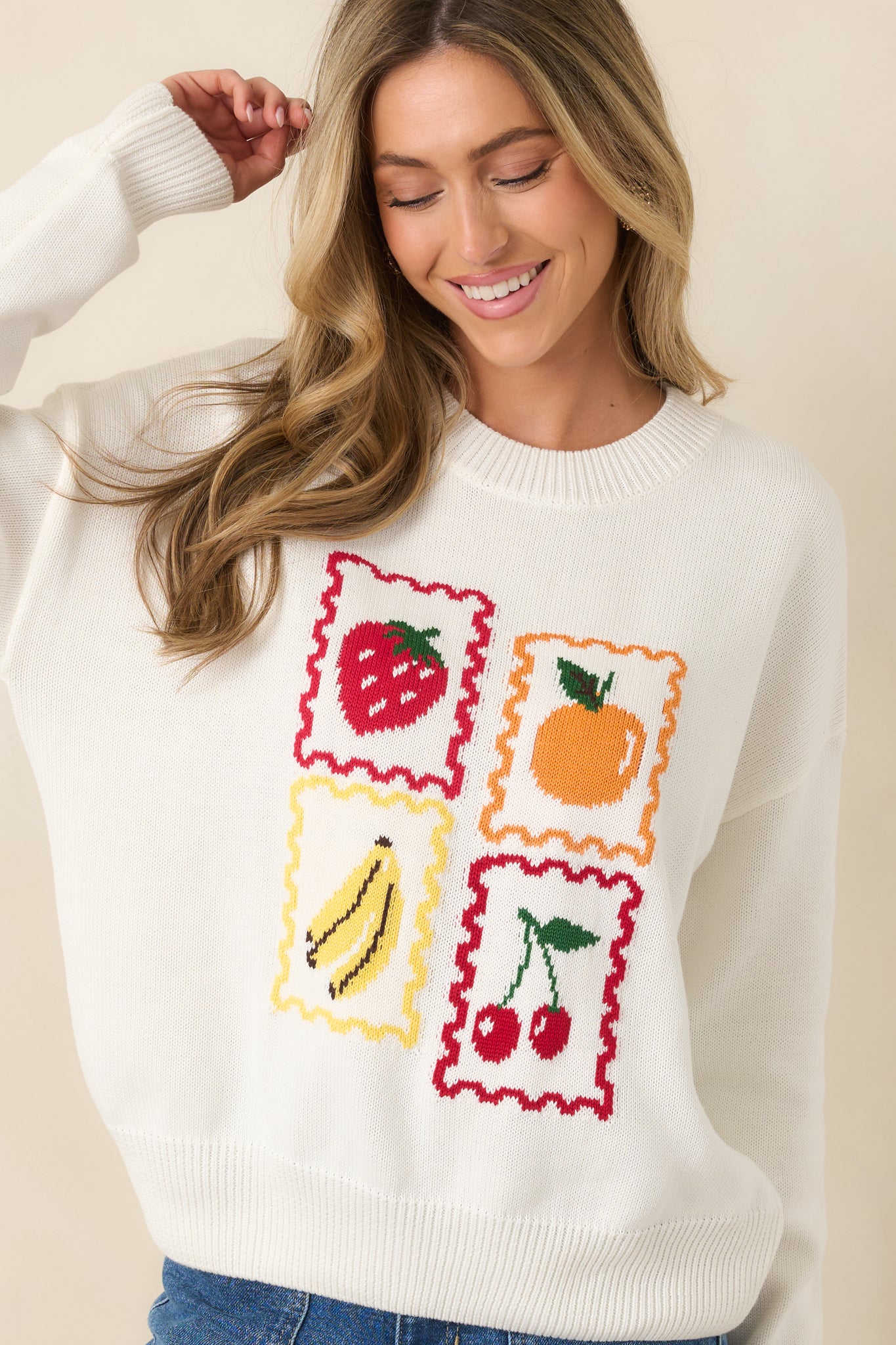 White pullover highlighting whimsical fruit prints in vibrant colors.