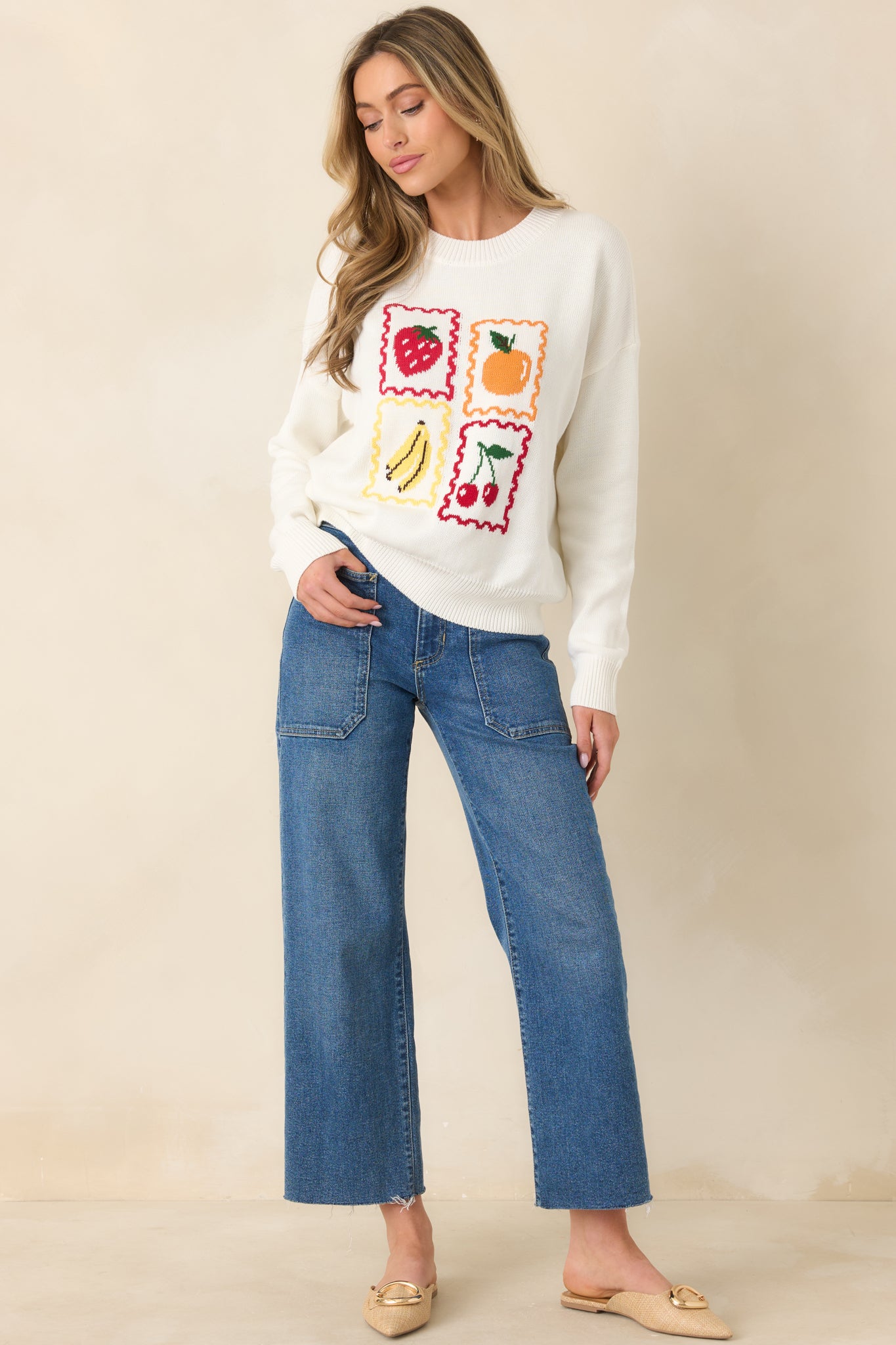 White pullover with playful fruit motifs and comfortable relaxed silhouette.