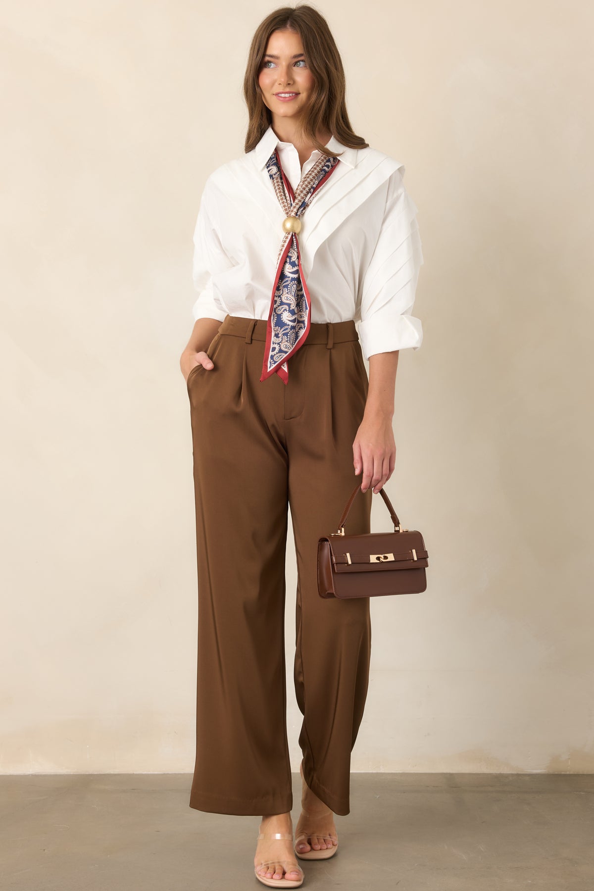 Wide-leg brown trousers with belt loops, front pleats, and functional pockets.