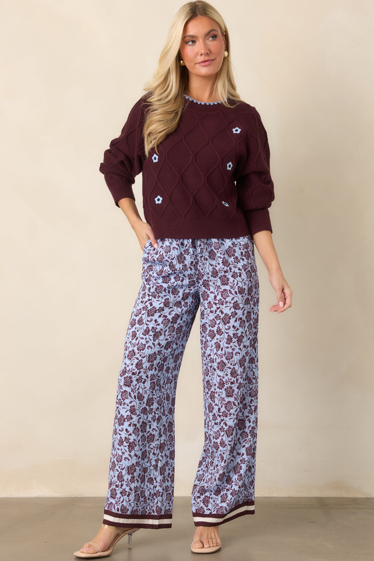 Wide-leg pants with burgundy floral detailing, a pale lilac ground, and burgundy and ivory striped hems.