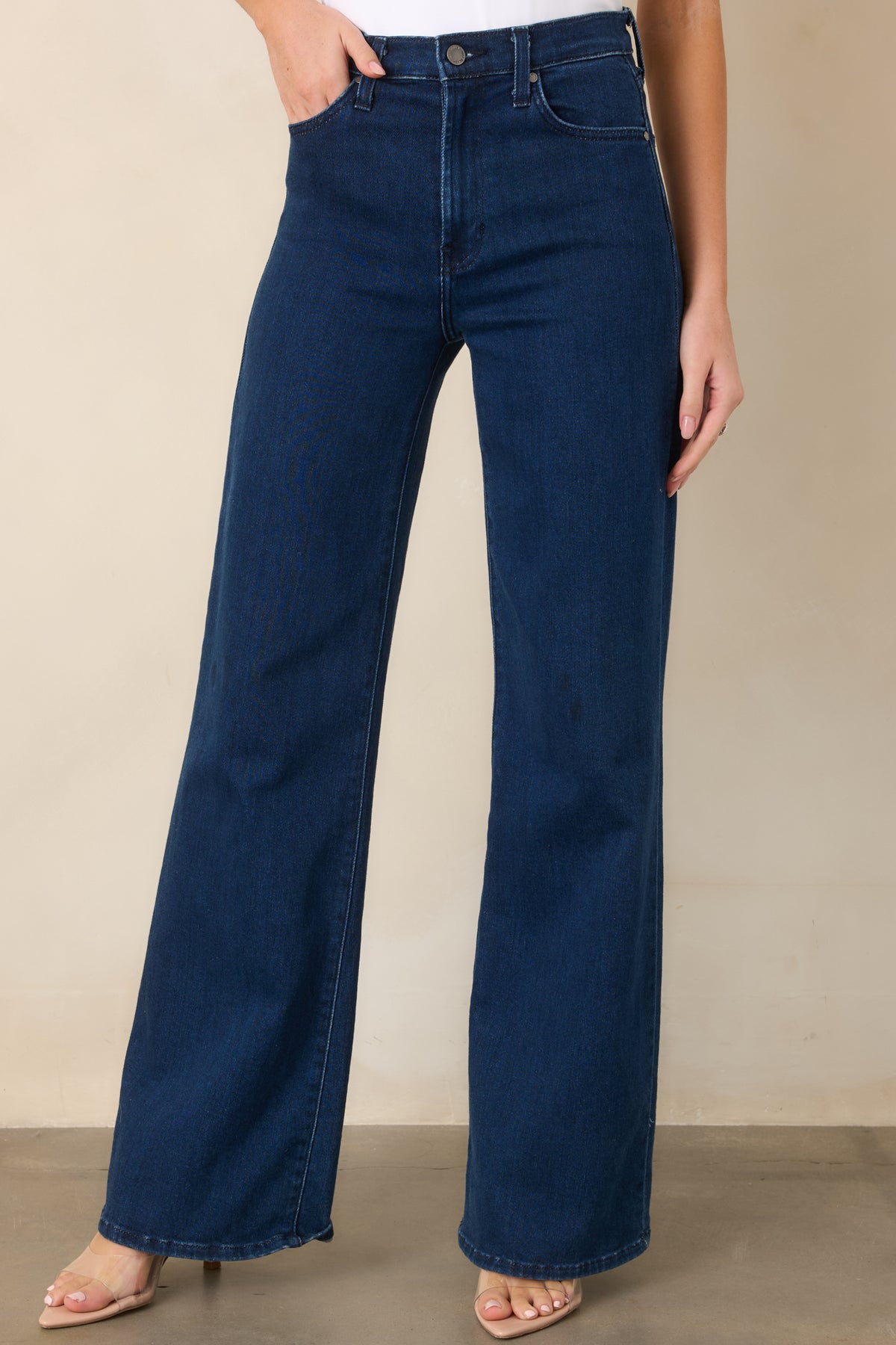 Wide-leg jeans featuring functional front pockets and a smooth dark wash finish.