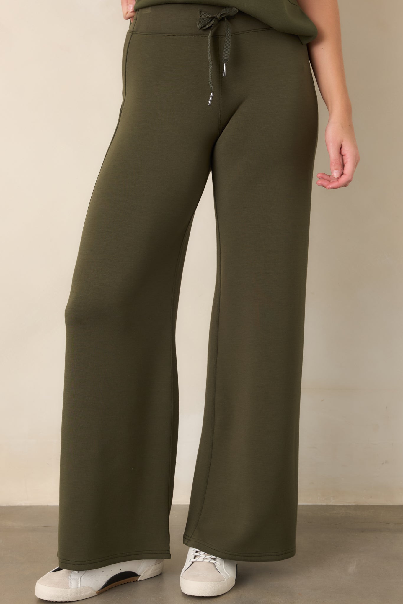 Close view of the wide-leg pants highlighting the pull-on waistband, adjustable drawstring, and smooth four-way stretch fabric.