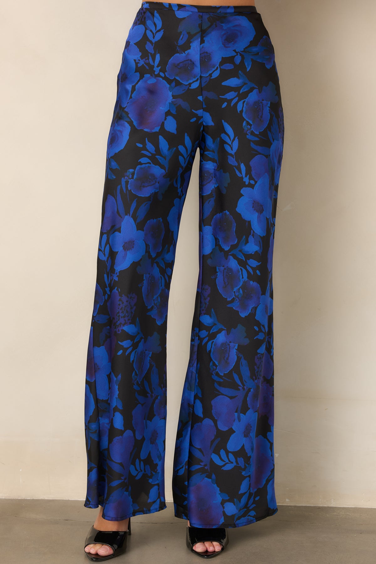 Wide-leg satin pants with a black base and colorful cobalt and violet floral detailing.
