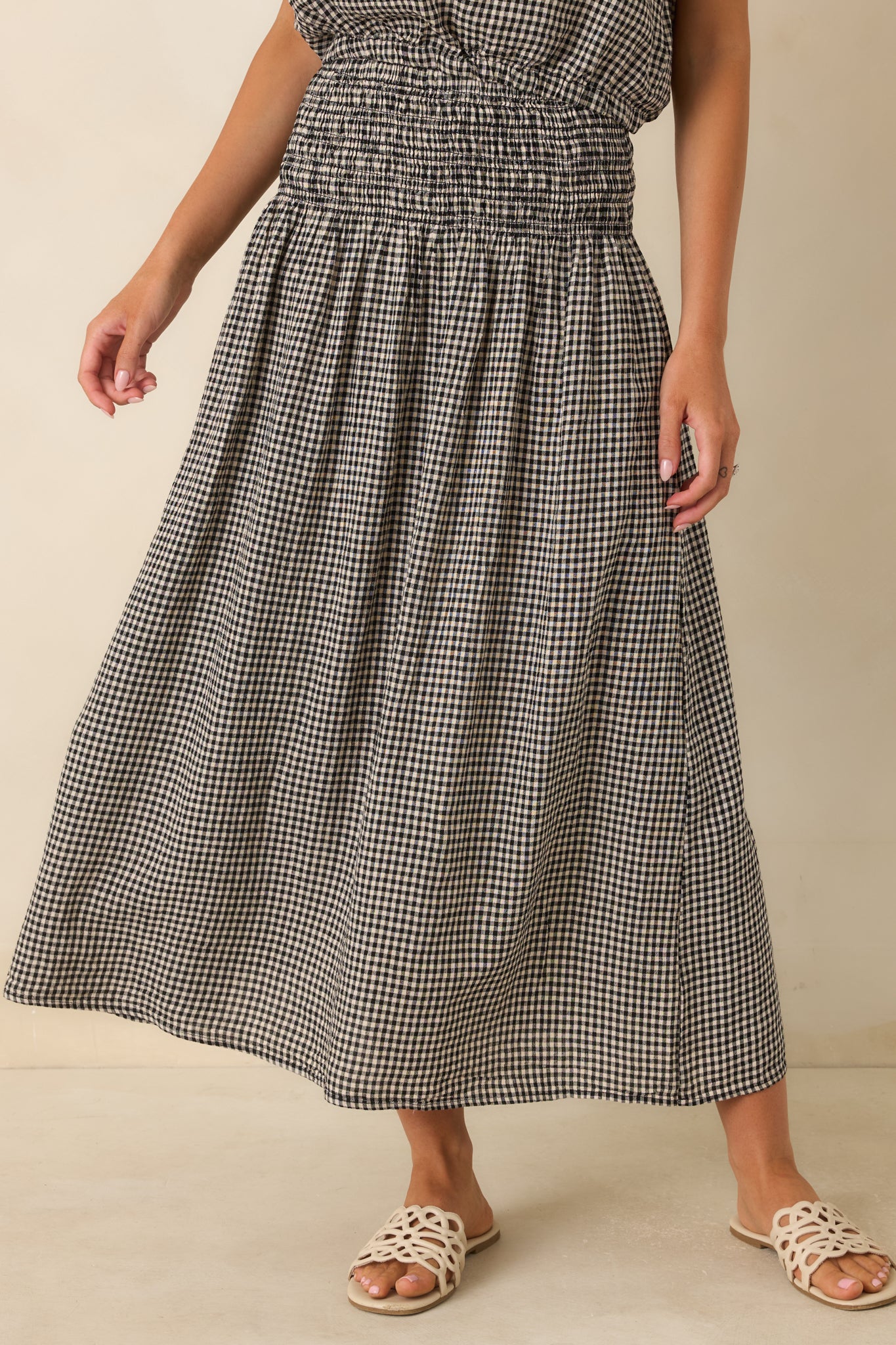 Detailed view of the wide smocked waistband and stretchy comfortable fit on the maxi skirt.