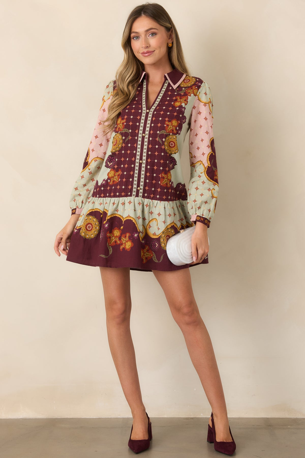Wine floral mini dress with geometric motifs, pointed collar, split neckline, and flounced hem.