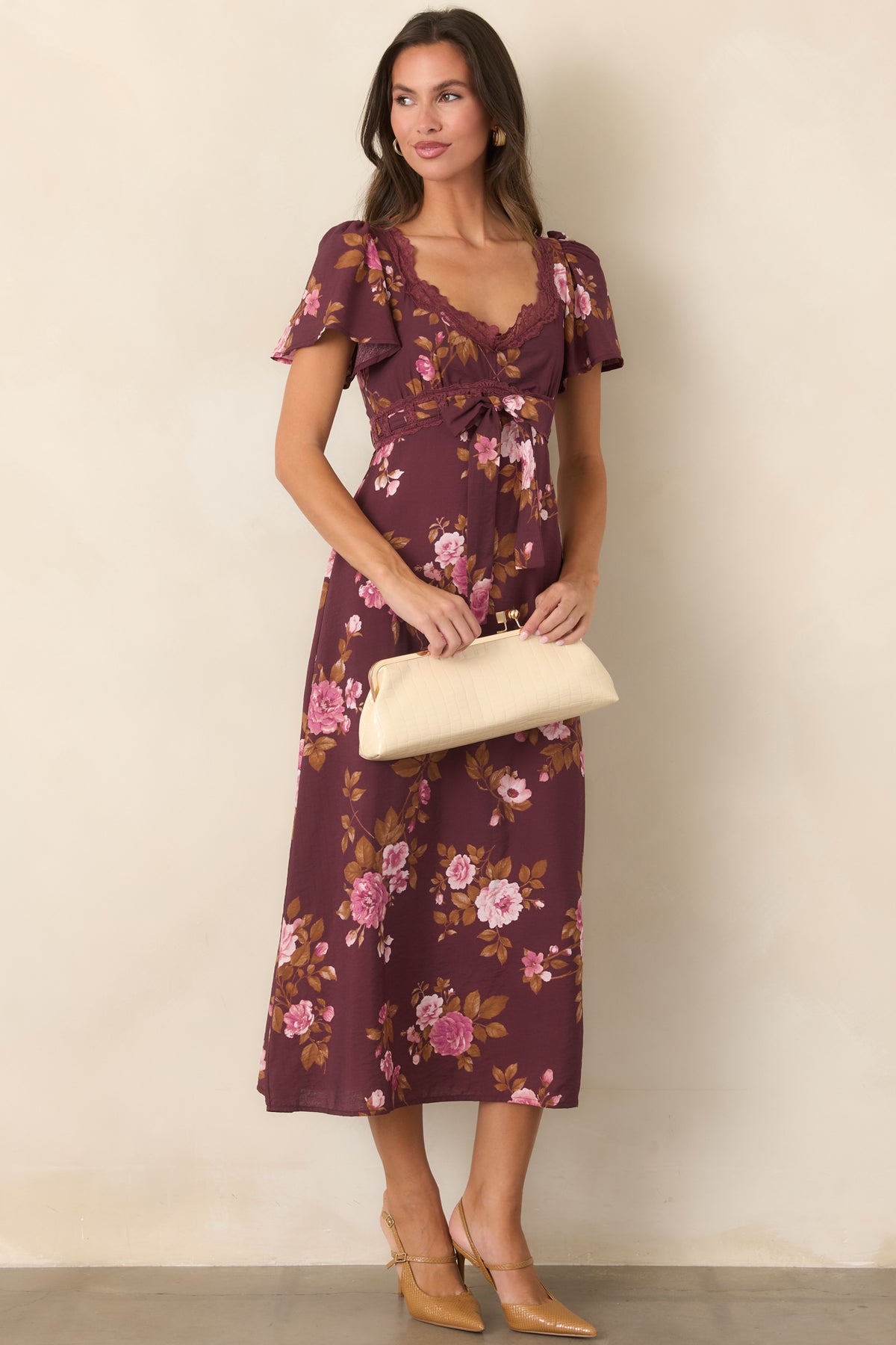 Wine floral midi dress featuring pink and blush blooms, golden brown leaves, a scalloped V-neckline, and flutter sleeves.